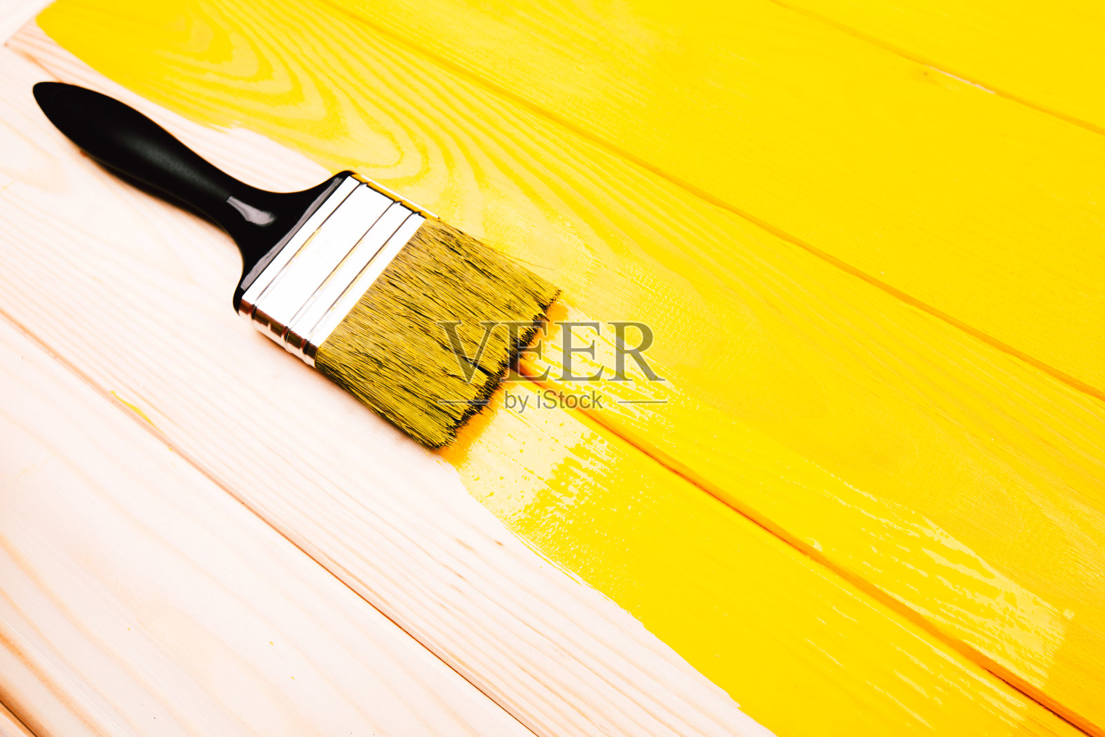 油漆刷在黄色半油漆木制背景。年度流行色照片摄影图片