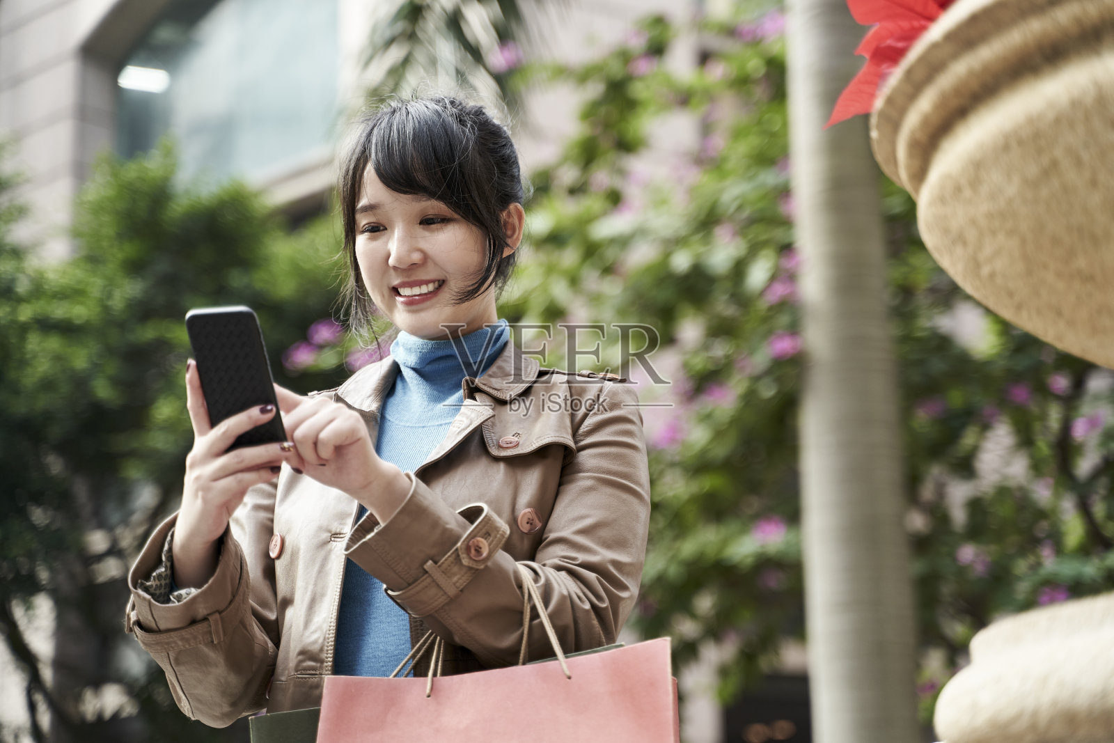 年轻的亚洲人在购物时用手机导航照片摄影图片