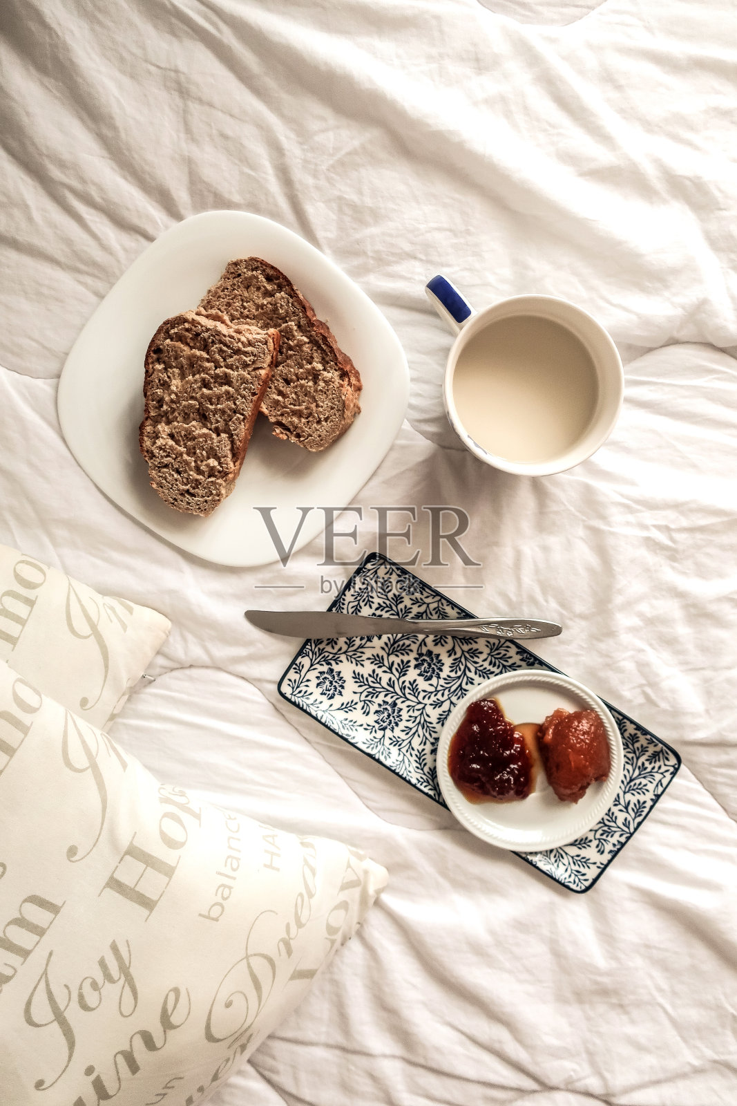 周日早上在床上吃早餐，一杯牛奶茶，面包和自制果酱照片摄影图片