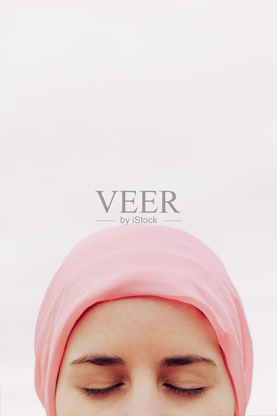 一张患有癌症的妇女闭着眼睛戴着粉色手帕的头像照片摄影图片