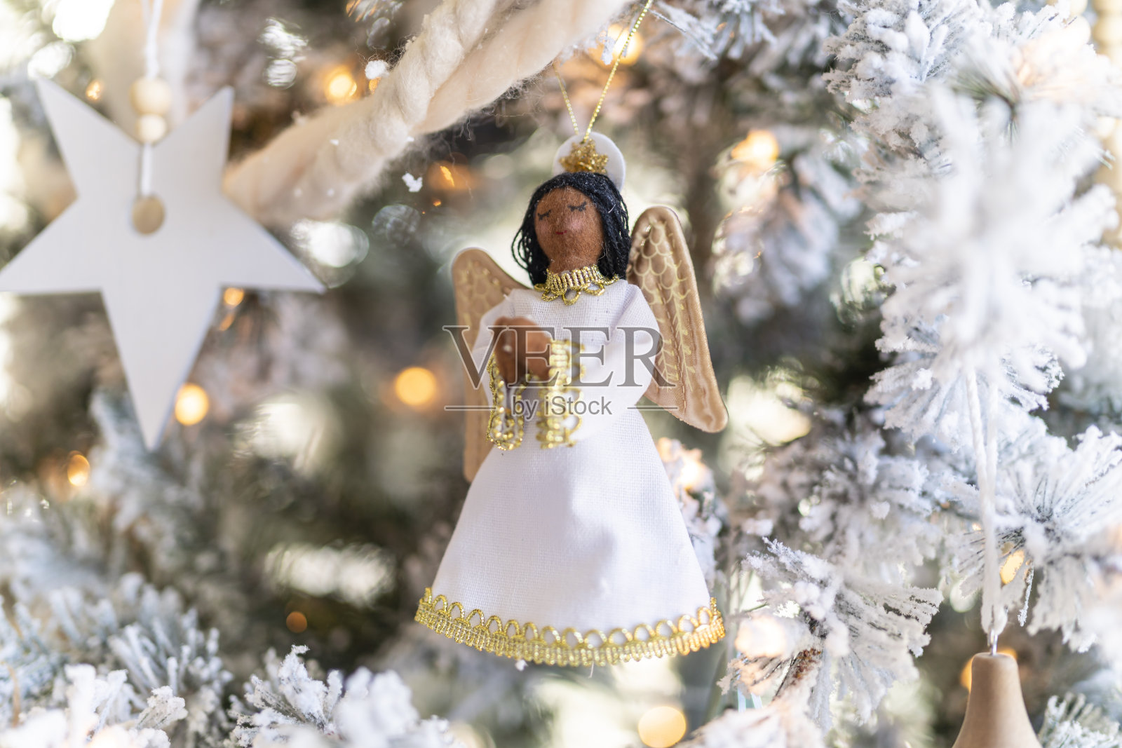近距离的天使圣诞装饰在蜂拥而至的树照片摄影图片