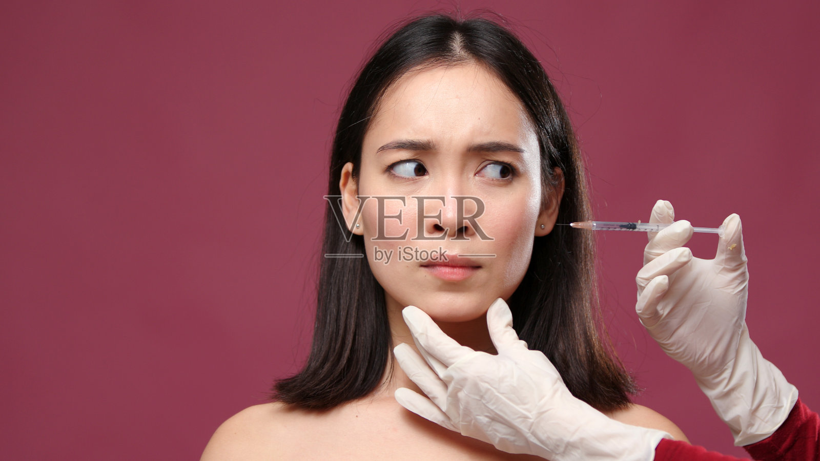年轻的亚洲女人害怕戴手套的医生试图给她脸上注射玛萨拉copyspace照片摄影图片