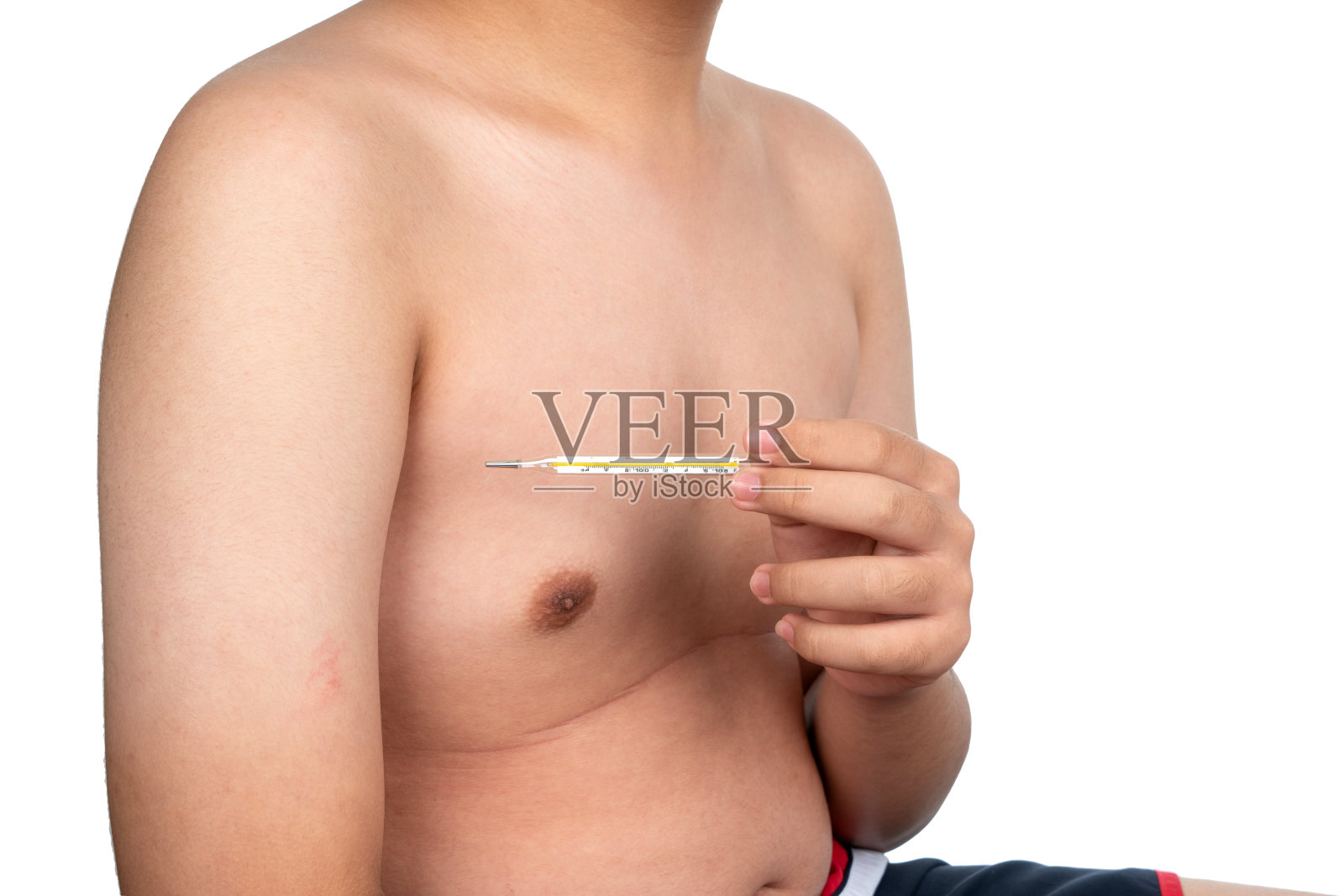 男孩胳膊下夹着一个玻璃体温计测量体温。医用体温计在孩子的腋下隔离在白色背景。照片摄影图片