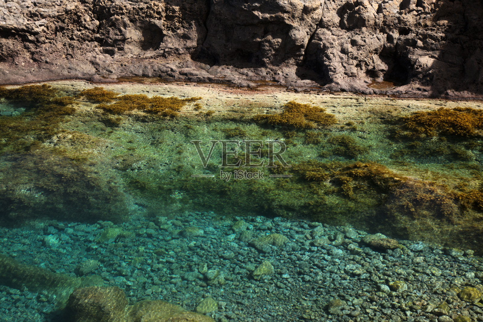 大卡纳利岛，平静的天然海水池在北部海岸陡峭的悬崖下，被火山岩石与海洋分离，撒丁岛del Norte地区照片摄影图片