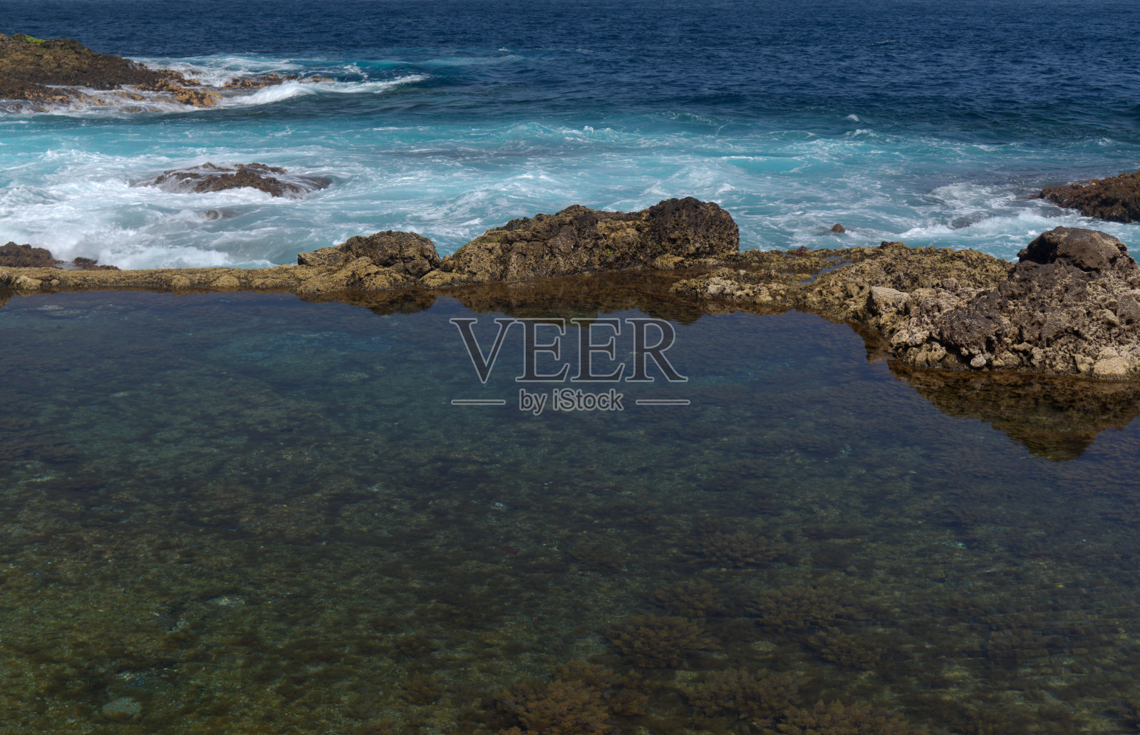 大卡纳利岛，平静的天然海水池在北部海岸陡峭的悬崖下，被火山岩石与海洋分离，撒丁岛del Norte地区照片摄影图片
