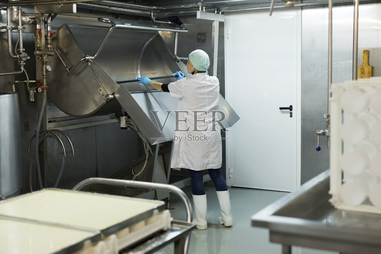 在奶酪和奶制品工厂洗罐的女人照片摄影图片