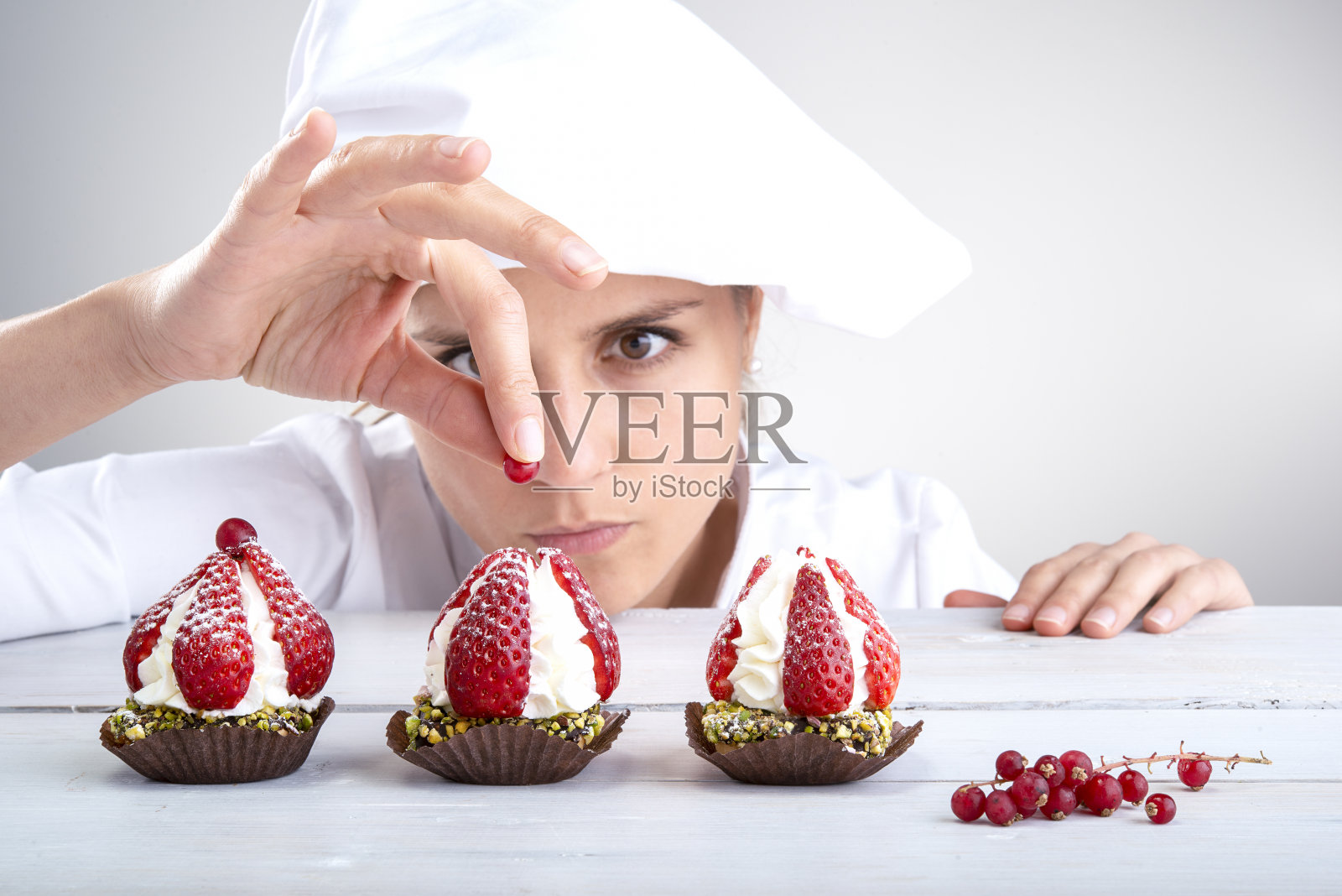 女糕点师装饰草莓蛋糕照片摄影图片