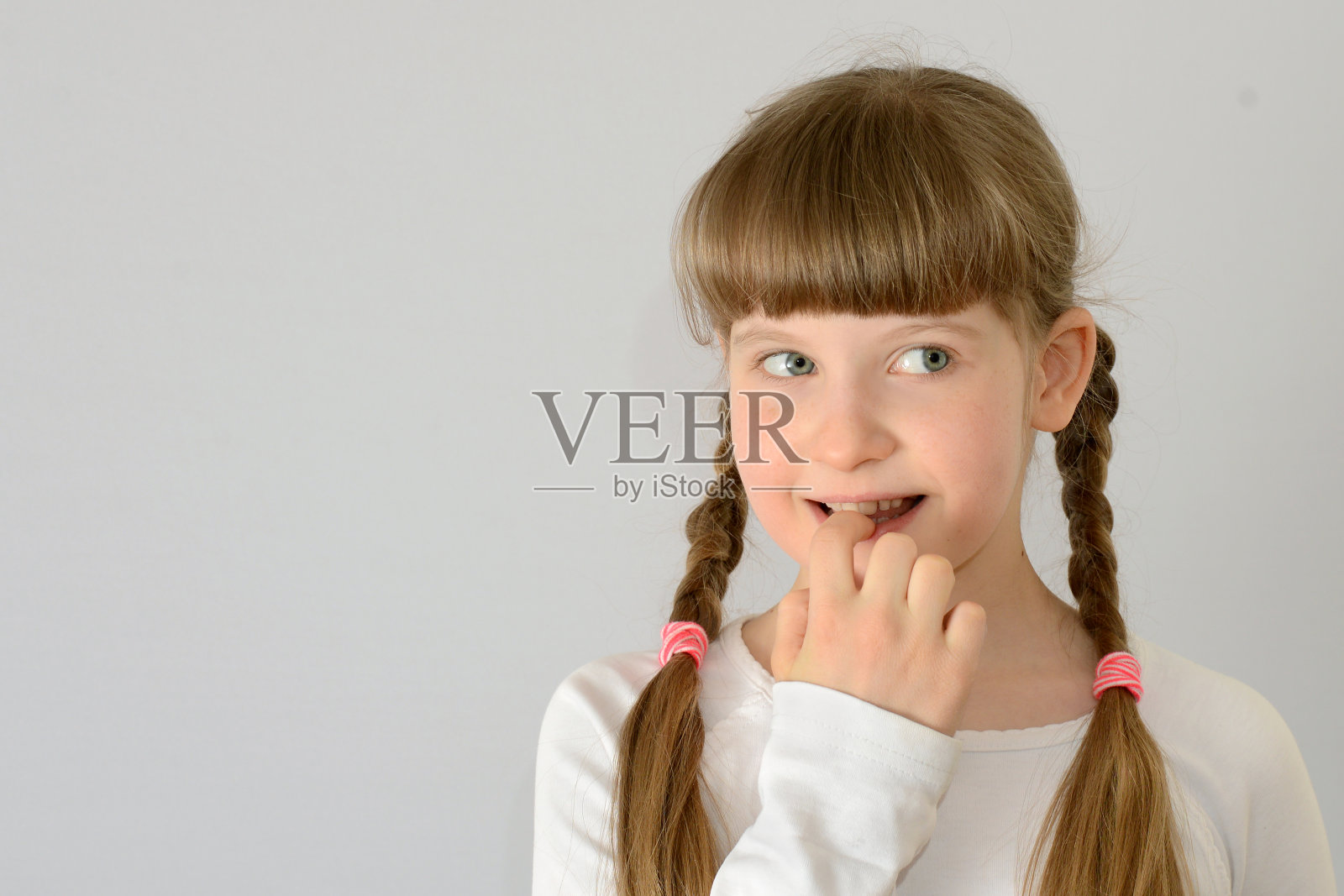 一个可爱的小女孩咬指甲照片摄影图片