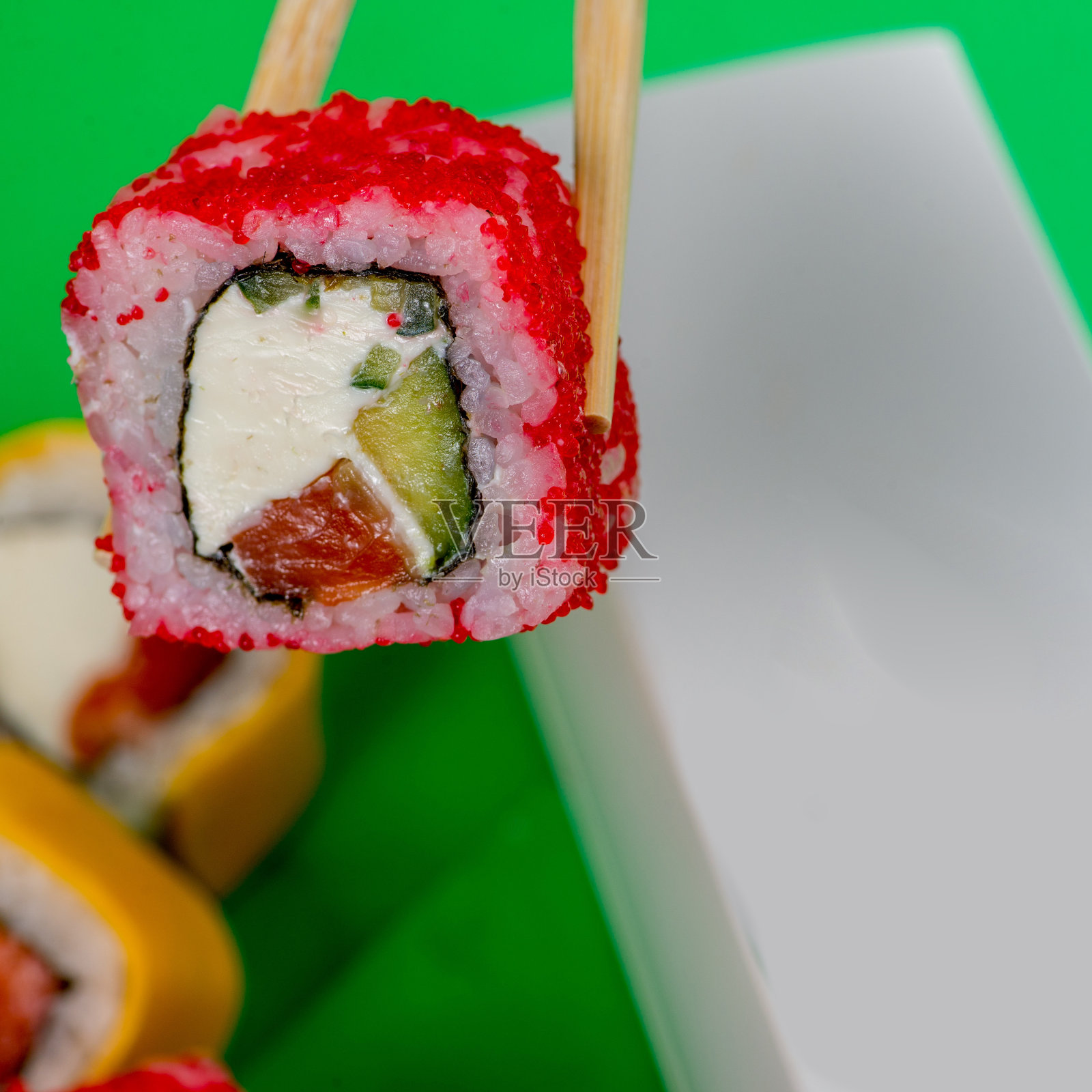 寿司配海鲜和奶油芝士是用筷子吃的。照片摄影图片