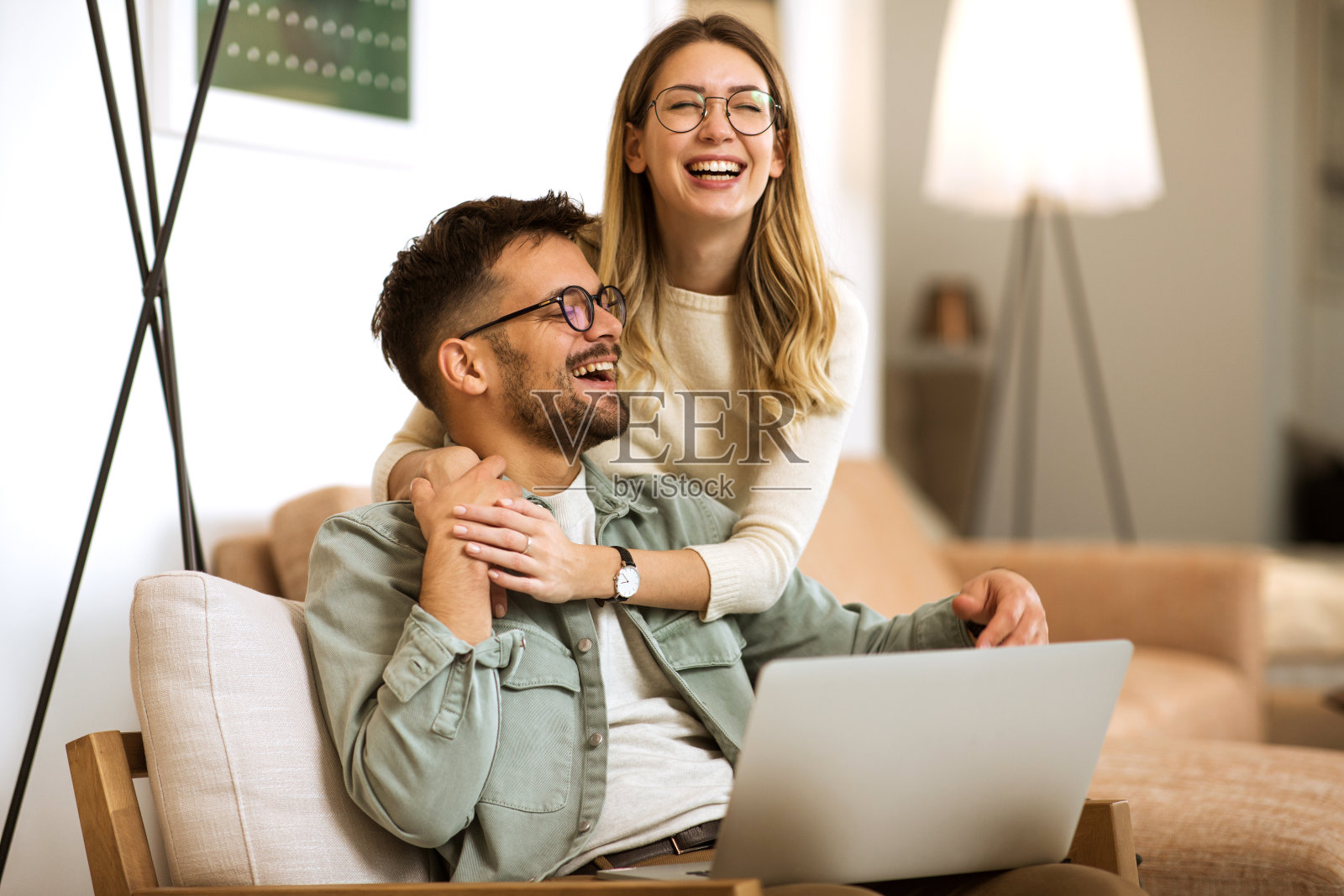 微笑的夫妇在家里放松，用笔记本电脑工作照片摄影图片