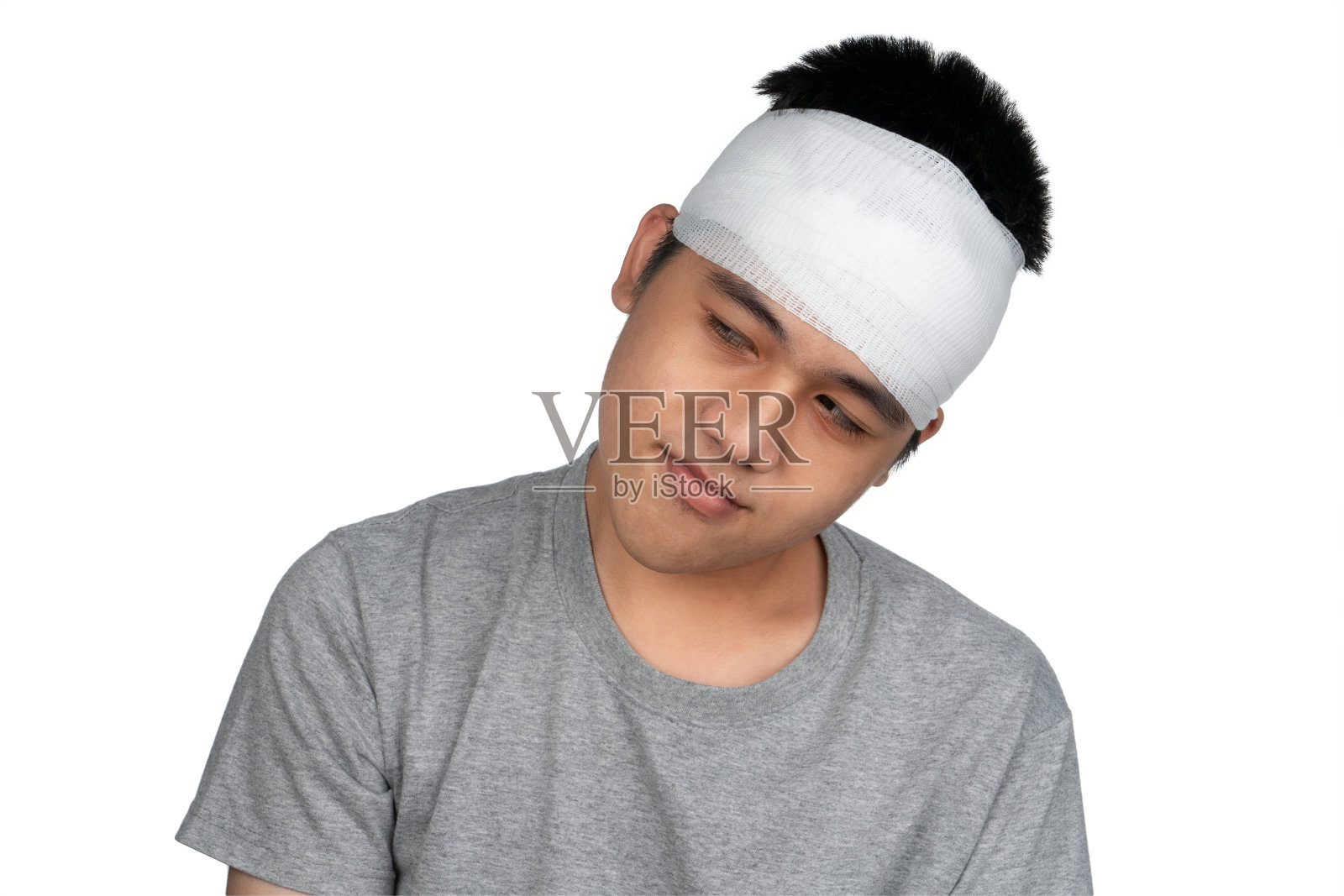 亚洲男孩脑震荡，头部受伤。一个头上缠着绷带的男孩。一个头部受伤的少年。在学校解剖头皮。照片摄影图片