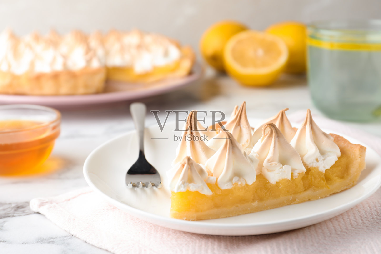 特写:白色大理石餐桌上美味的柠檬酥皮派照片摄影图片