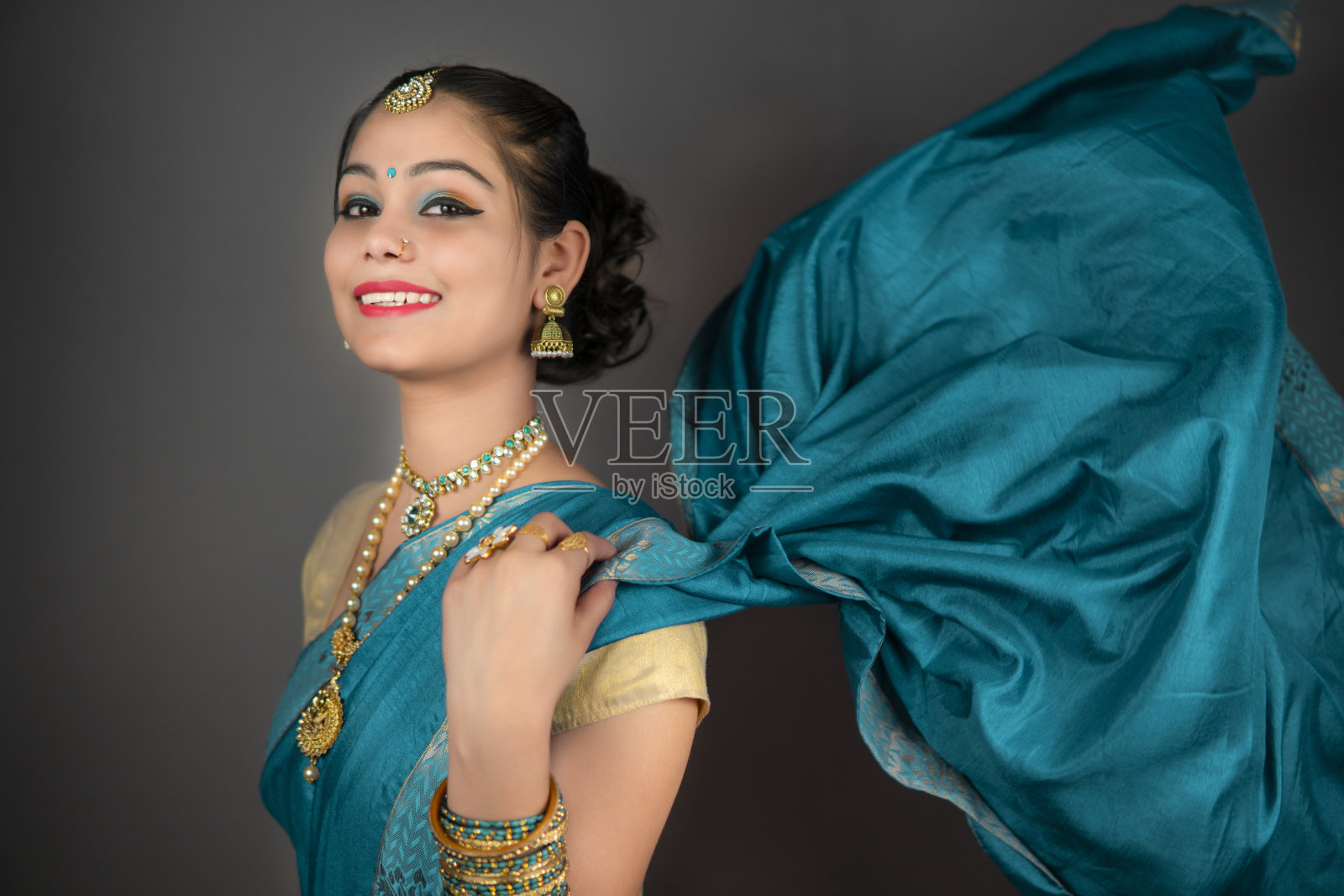 这是一个穿着传统印度纱丽和珠宝的漂亮女人的肖像。照片摄影图片