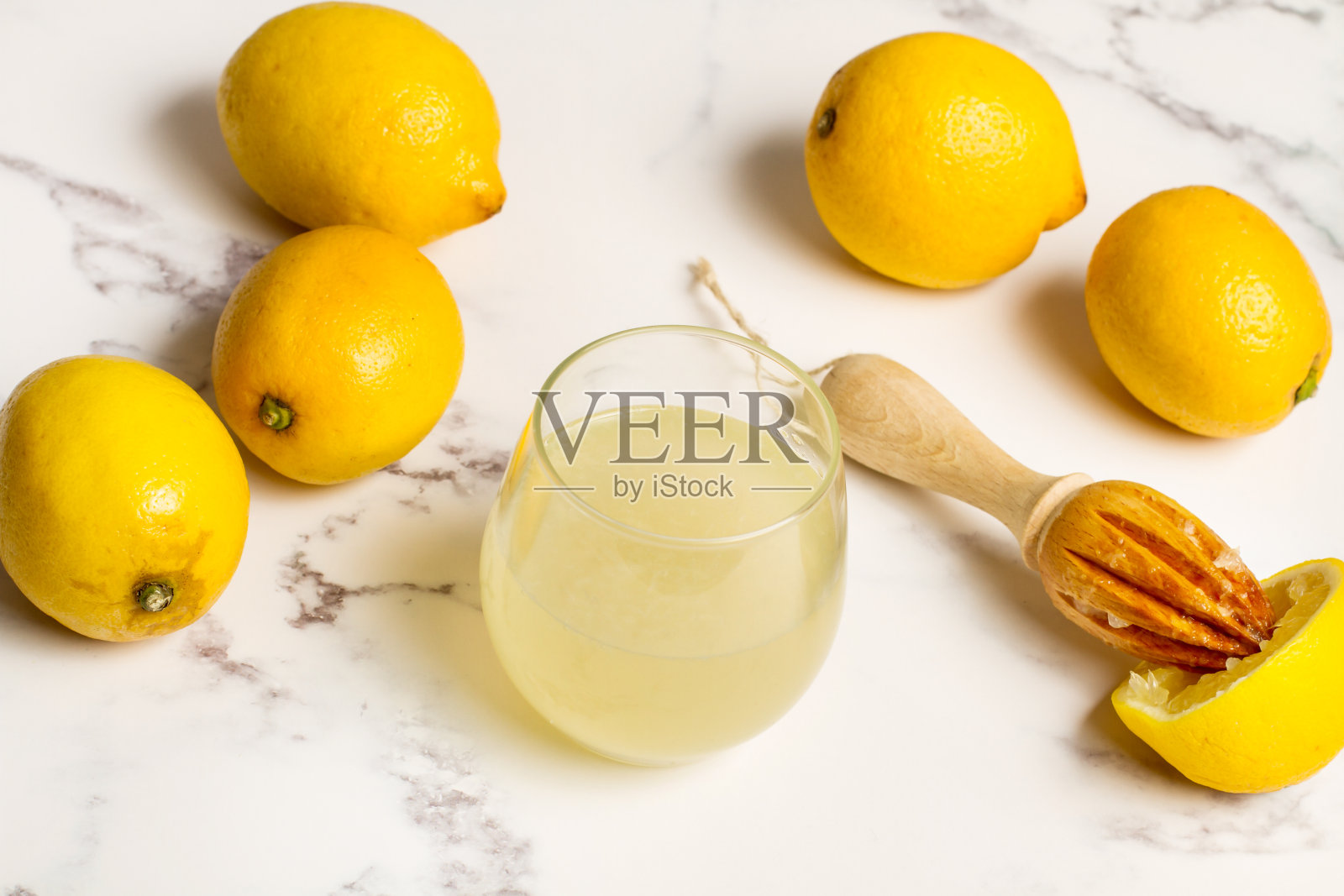 大理石桌子上放着柠檬和一杯柠檬汁照片摄影图片