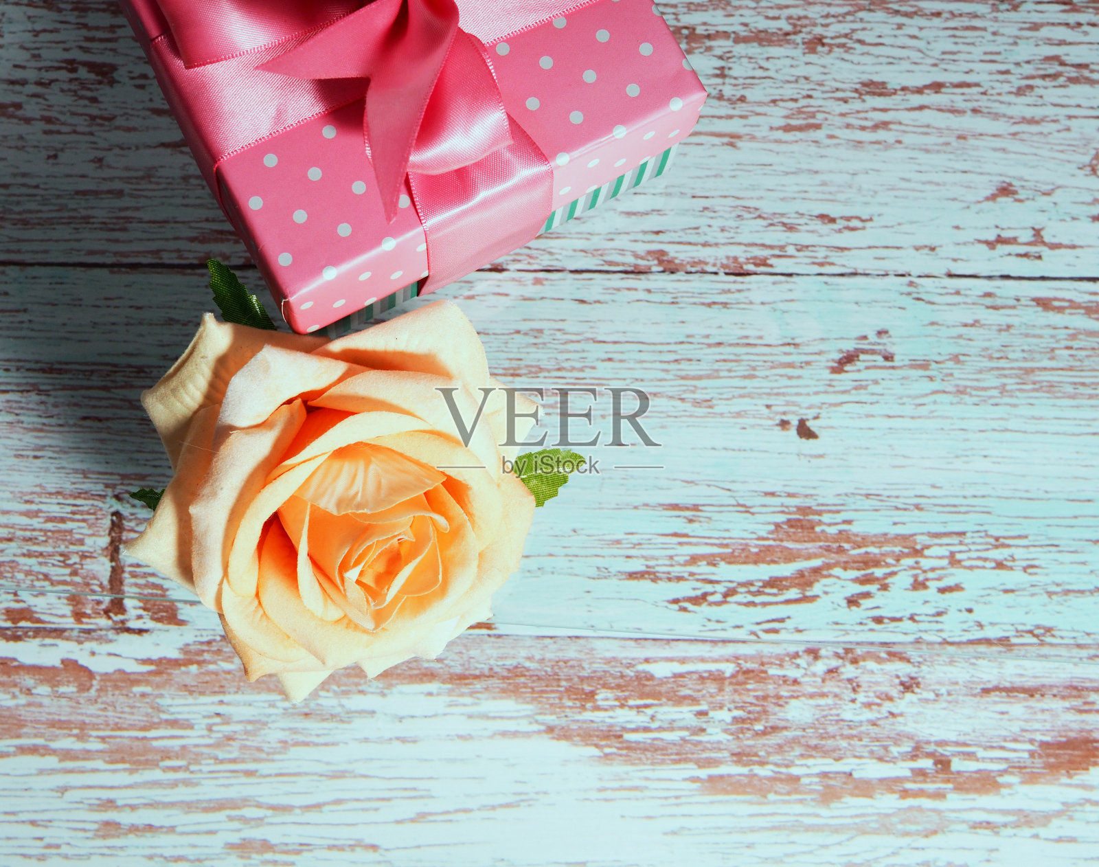 一个礼盒上有一个粉红色的蝴蝶结在一个木制的背景，一个文本空间的副本上升附近照片摄影图片