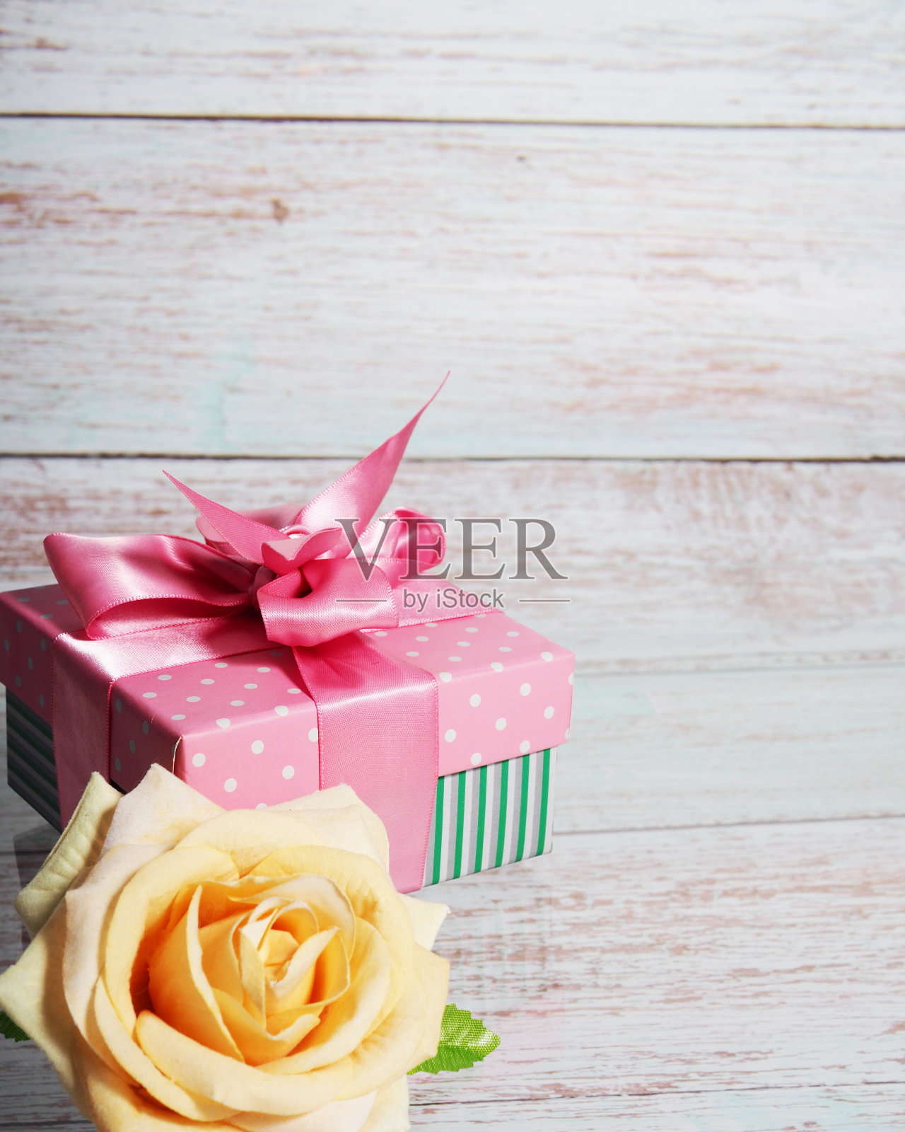 一个礼盒上有一个粉红色的蝴蝶结在一个木制的背景，一个文本空间的副本上升附近照片摄影图片