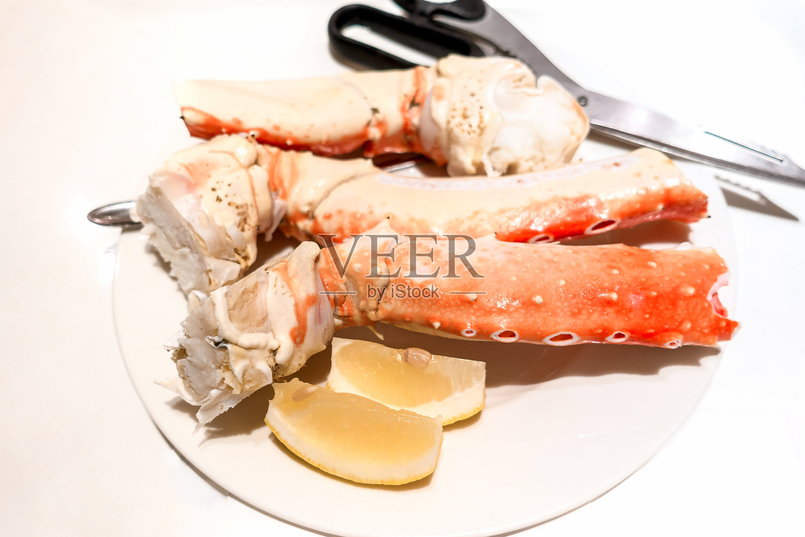 煮熟的蟹趾放在一个白色的盘子里。照片摄影图片