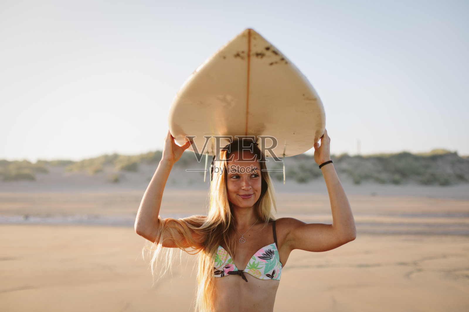 在海滩上玩冲浪板的快乐女人照片摄影图片