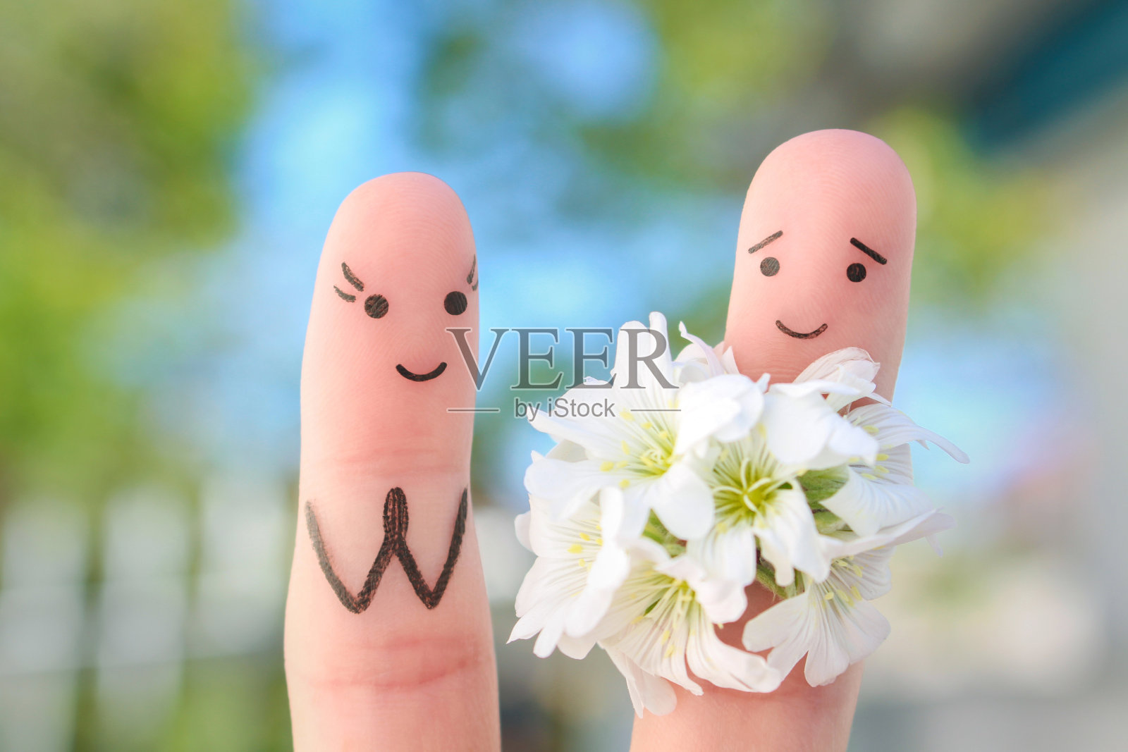 幸福夫妻的手指艺术。男人正在送花给女人。照片摄影图片