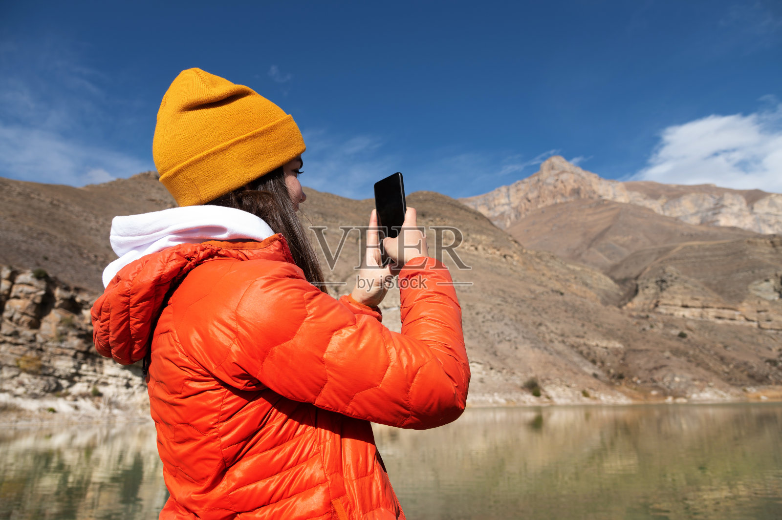 一名年轻的白人女性在山里用智能手机拍照照片摄影图片