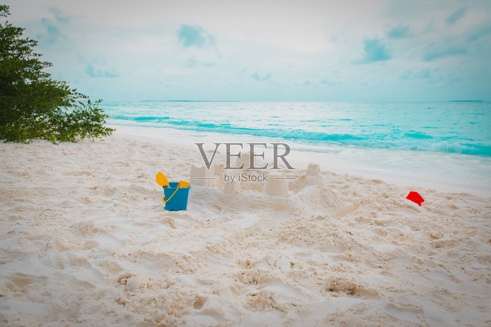 热带海滩上的儿童玩具和沙堡照片摄影图片
