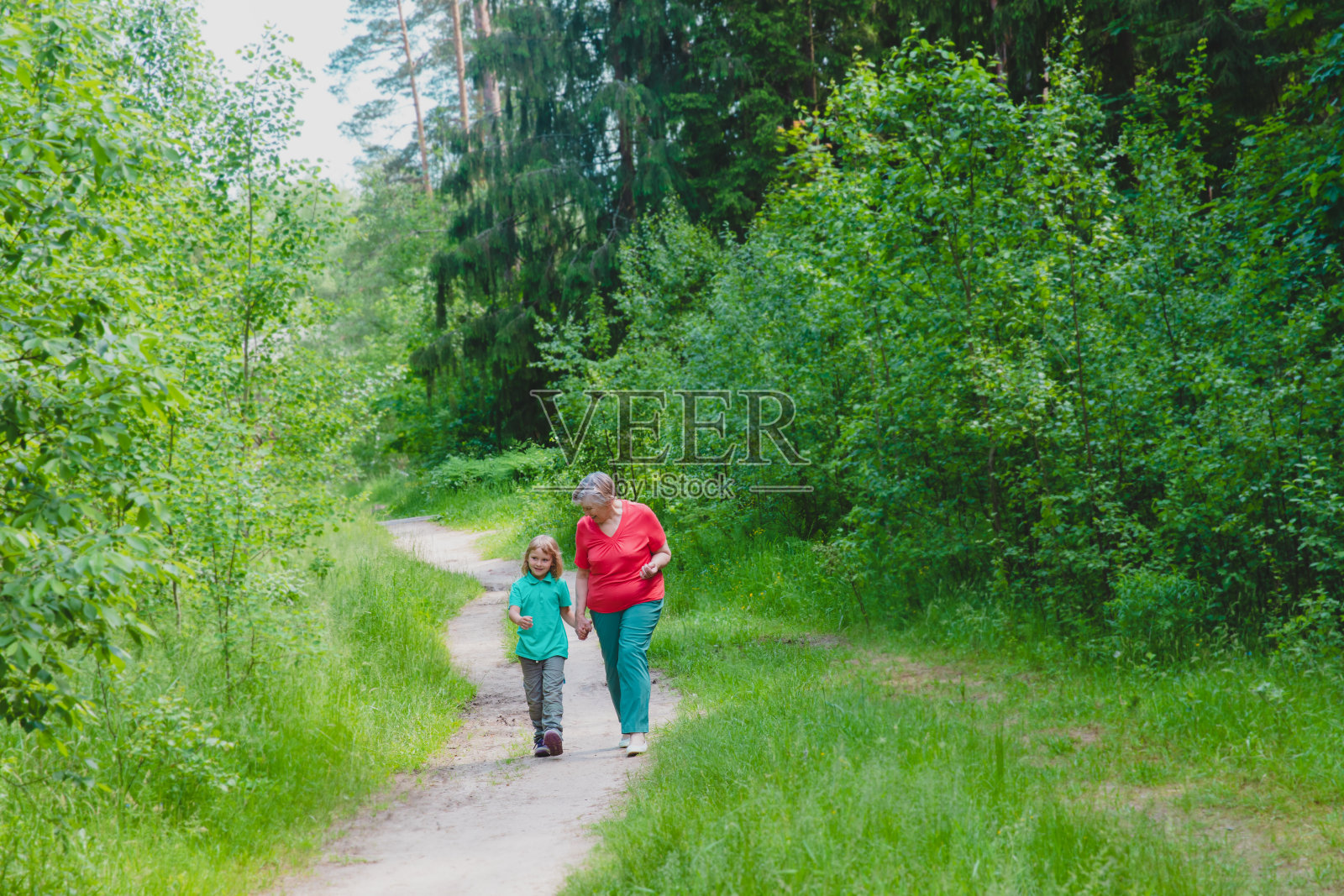 快乐的老祖母带着孙女在大自然中漫步照片摄影图片