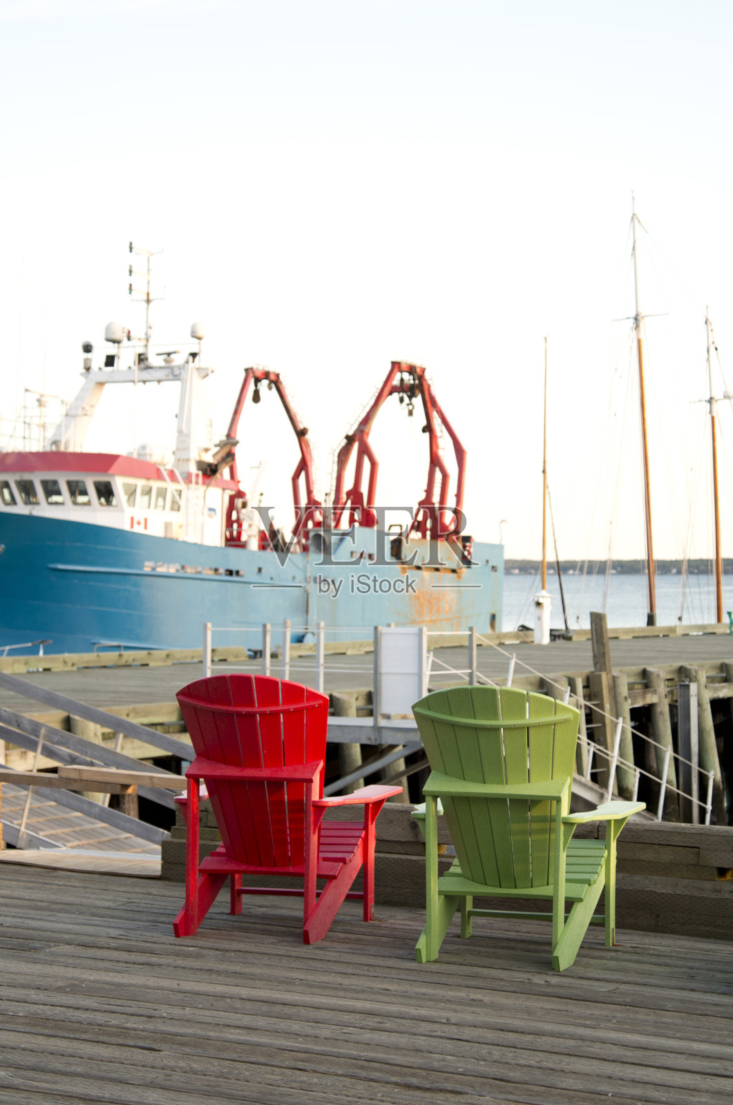 木制码头上的阿迪朗达克椅子。照片摄影图片
