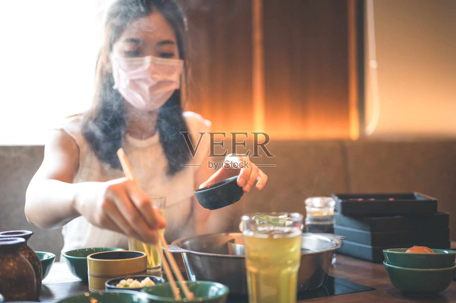 微笑的亚洲人戴着面具在亚洲等待享受日本涮锅自助餐照片摄影图片