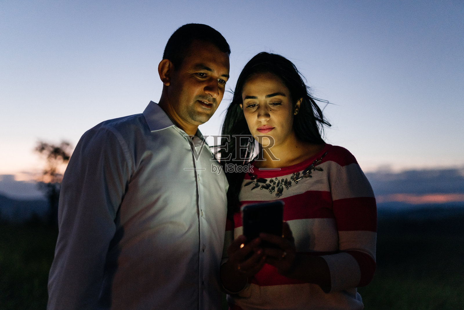 情侣们在黄昏时分使用智能手机照片摄影图片
