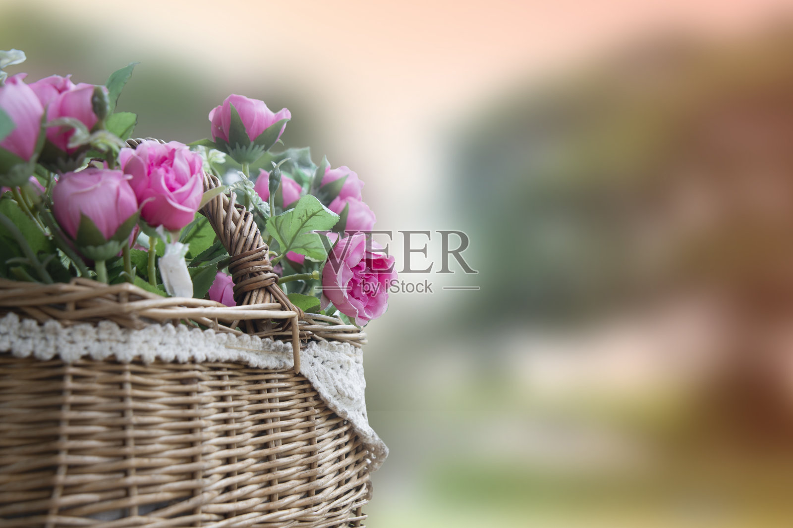 布制人造花，装裱在花篮里，衬托出花朵的美丽。照片摄影图片