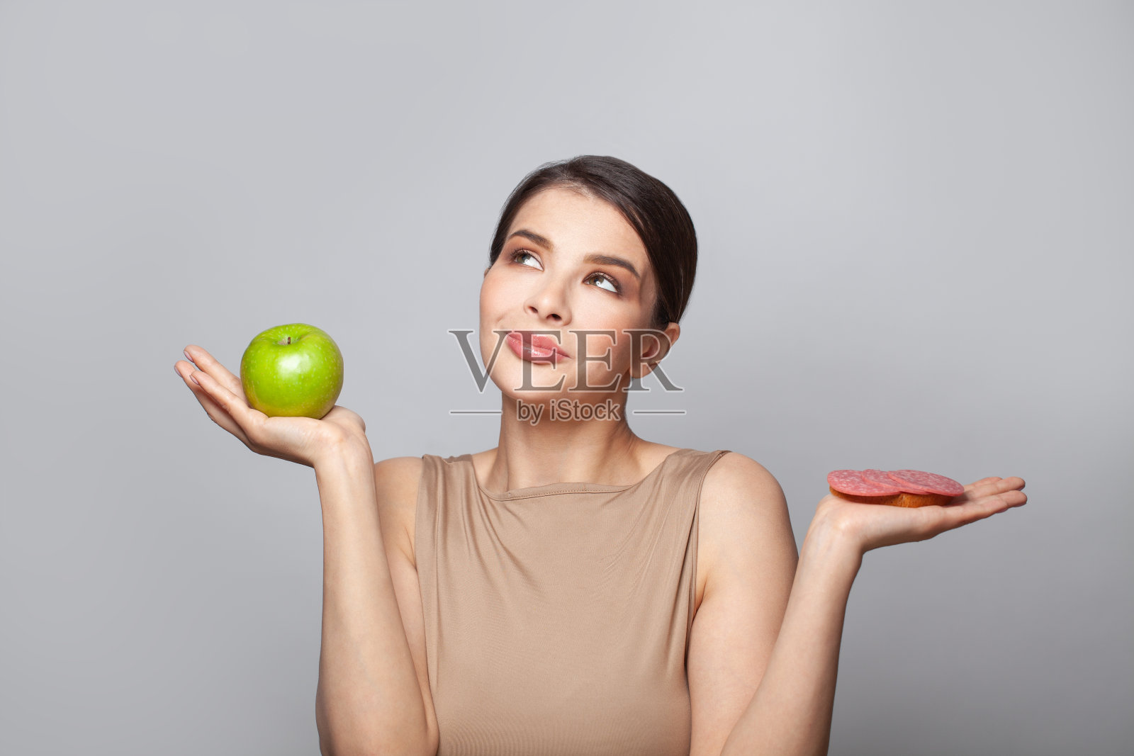 饮食。节食的概念。健康食品。美丽的年轻女子选择水果和三明治。减肥照片摄影图片