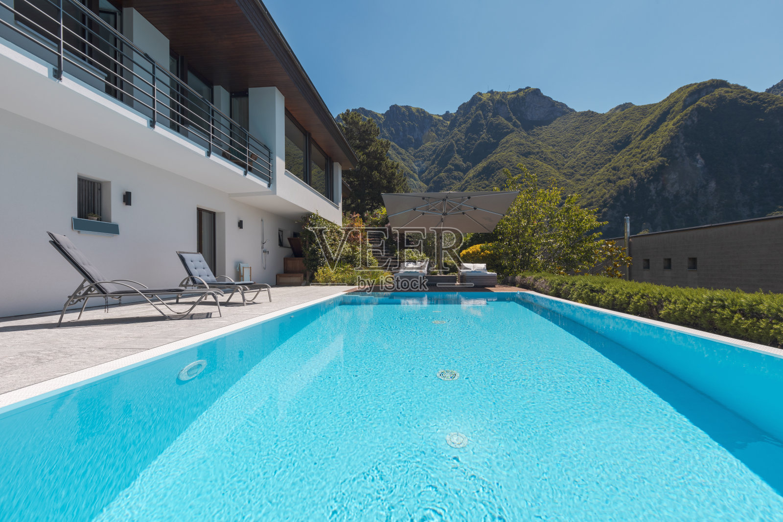 带大游泳池的现代两层住宅俯瞰群山。照片摄影图片