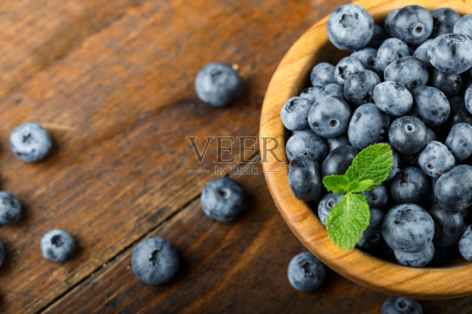 新鲜采摘的蓝莓放在木碗里。健康浆果，有机食品照片摄影图片