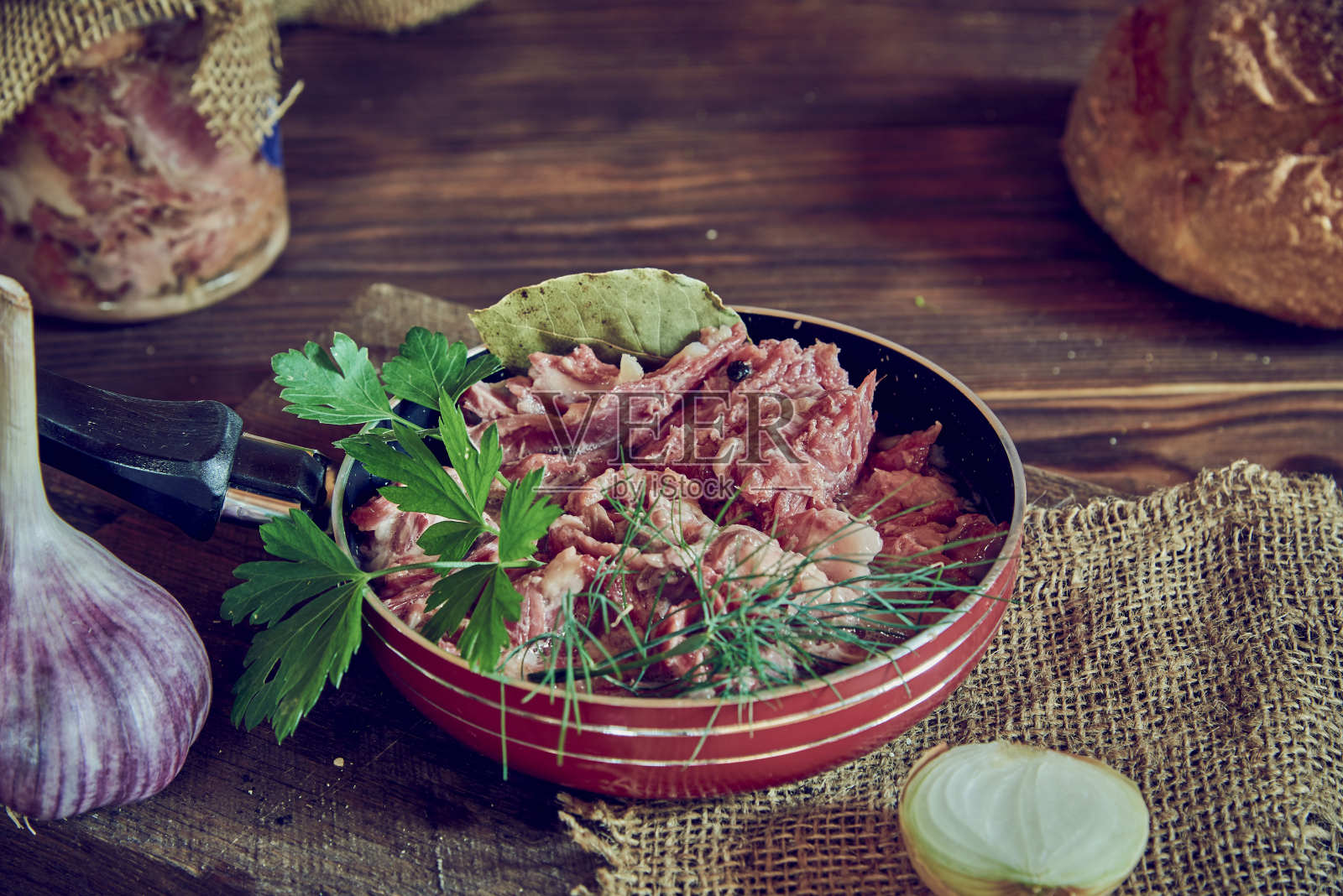 木制的平底锅上放着用新鲜香草调味的炖肉。照片摄影图片