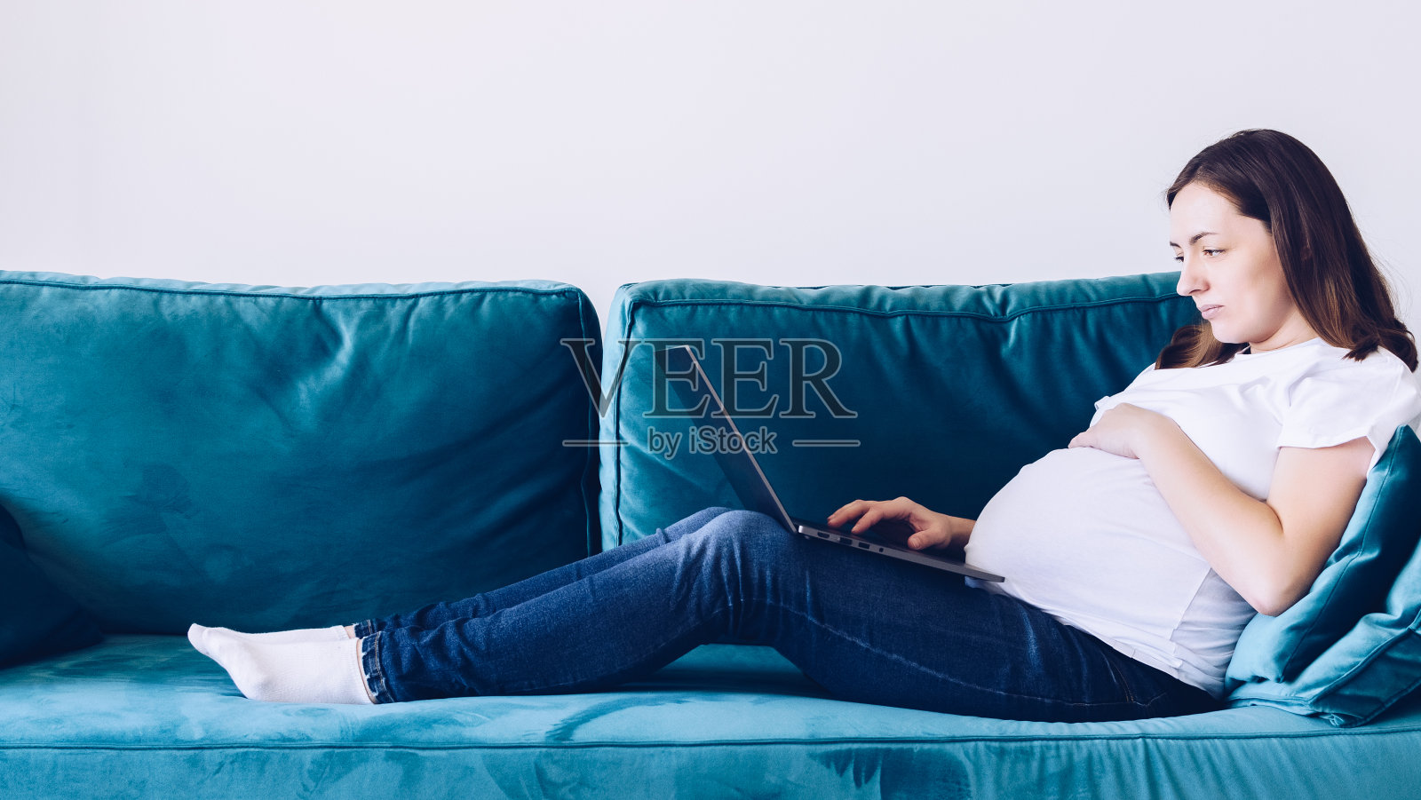 孕妇坐在沙发上用笔记本电脑照片摄影图片