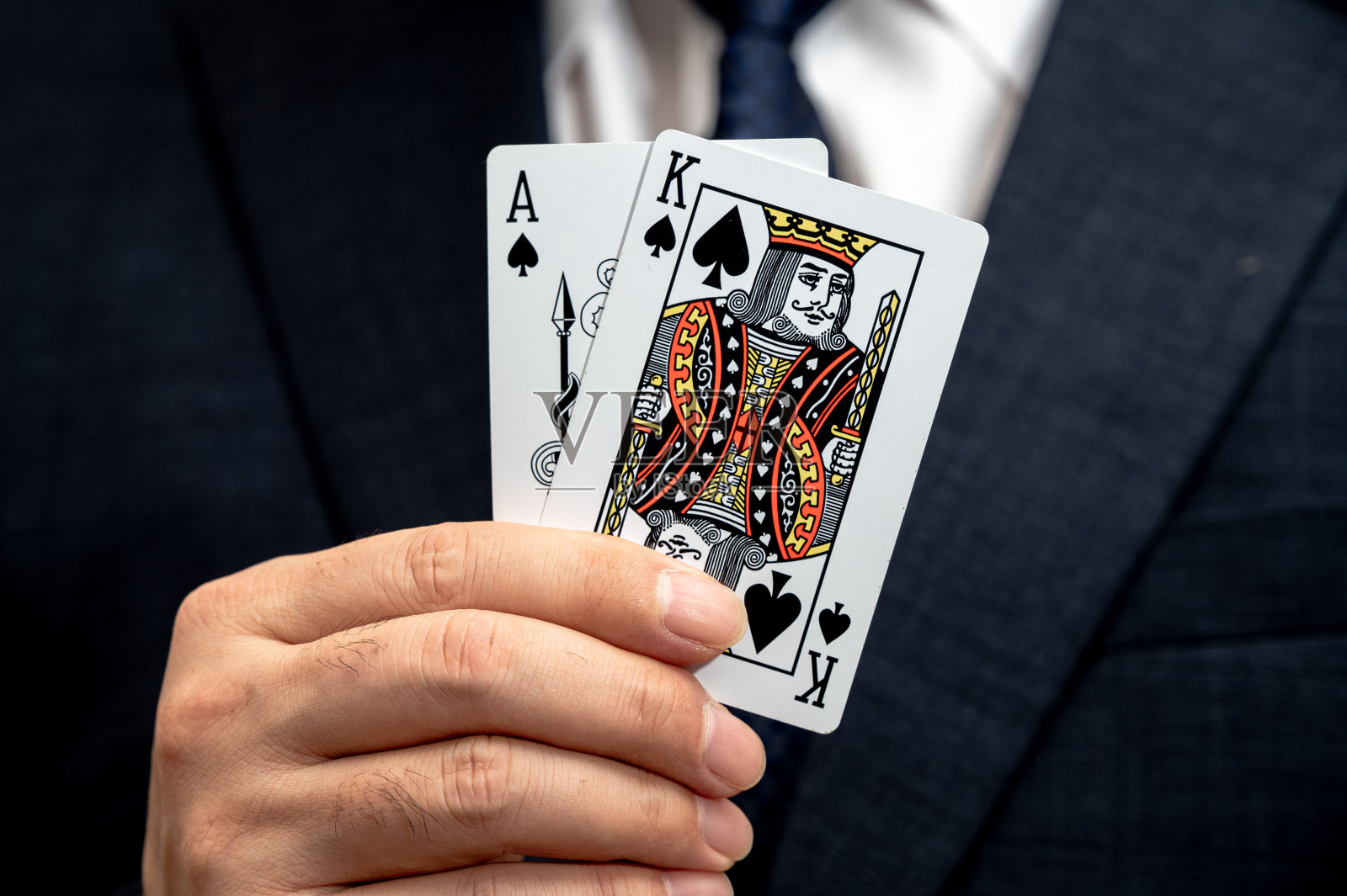 扑克之王牌在西装革履的商人手中。照片摄影图片