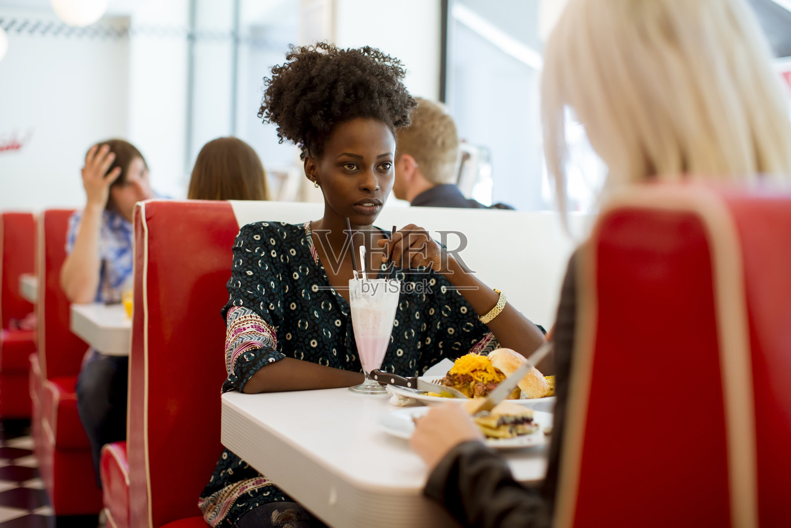 多种族的女性朋友在餐厅的餐桌上吃快餐照片摄影图片