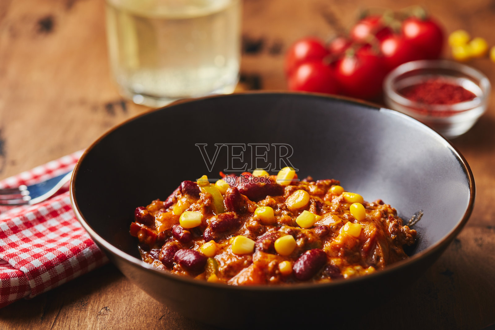 在黑色的碗里，木制背景上有碎牛肉，豆子和玉米。墨西哥和德州美食照片摄影图片