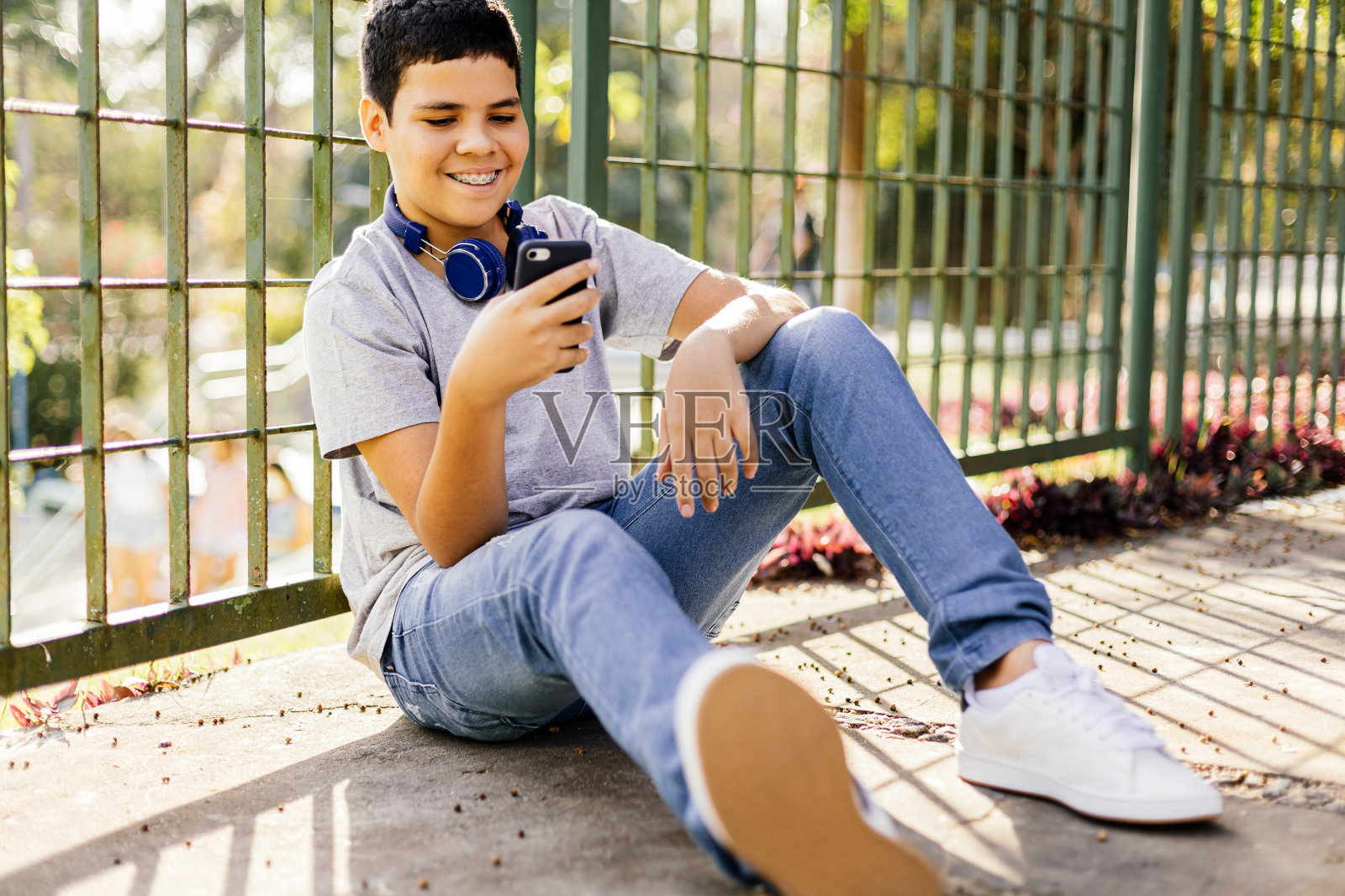 12岁男孩在户外使用智能手机。照片摄影图片