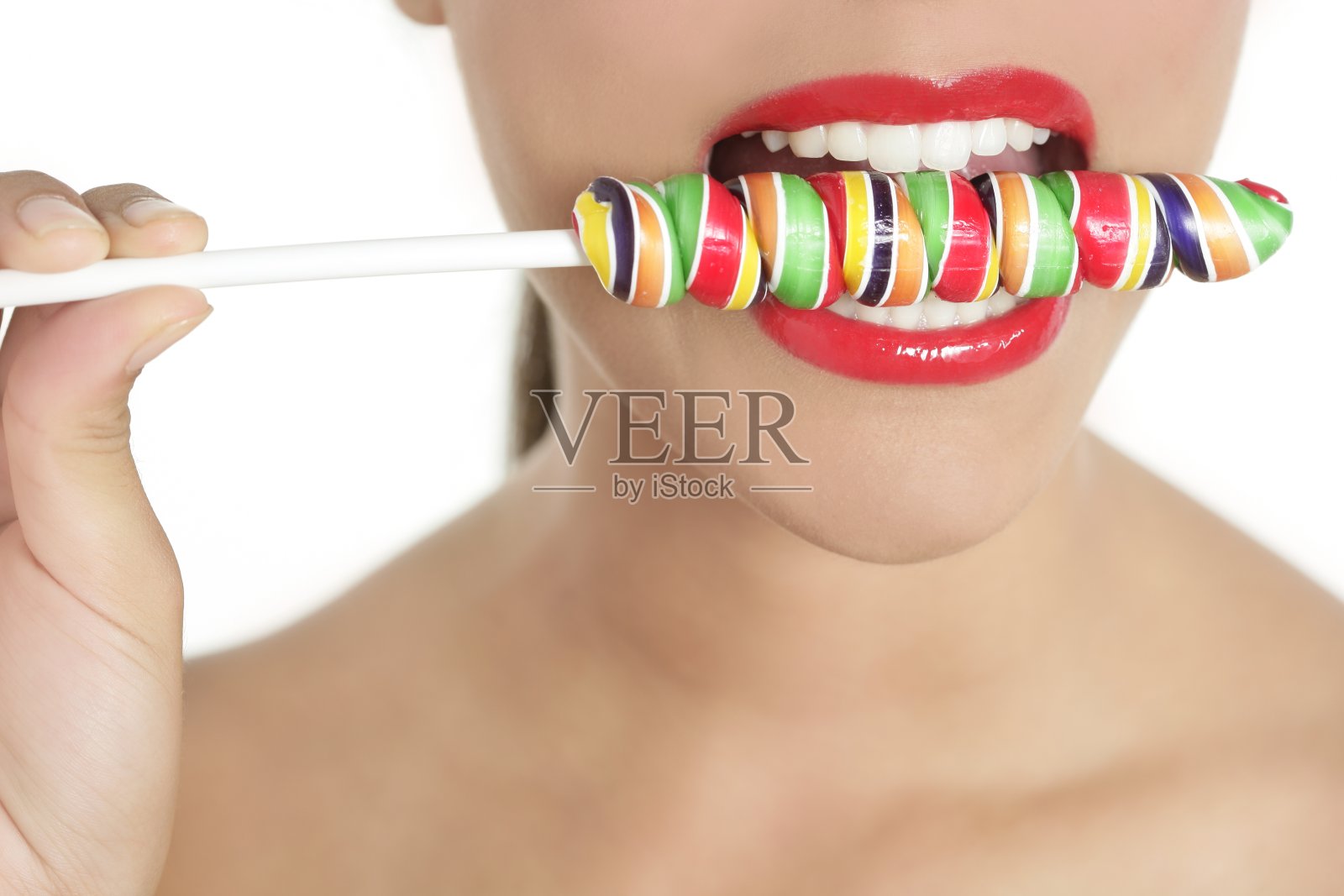 五颜六色的棒棒糖在完美女人的牙齿上照片摄影图片