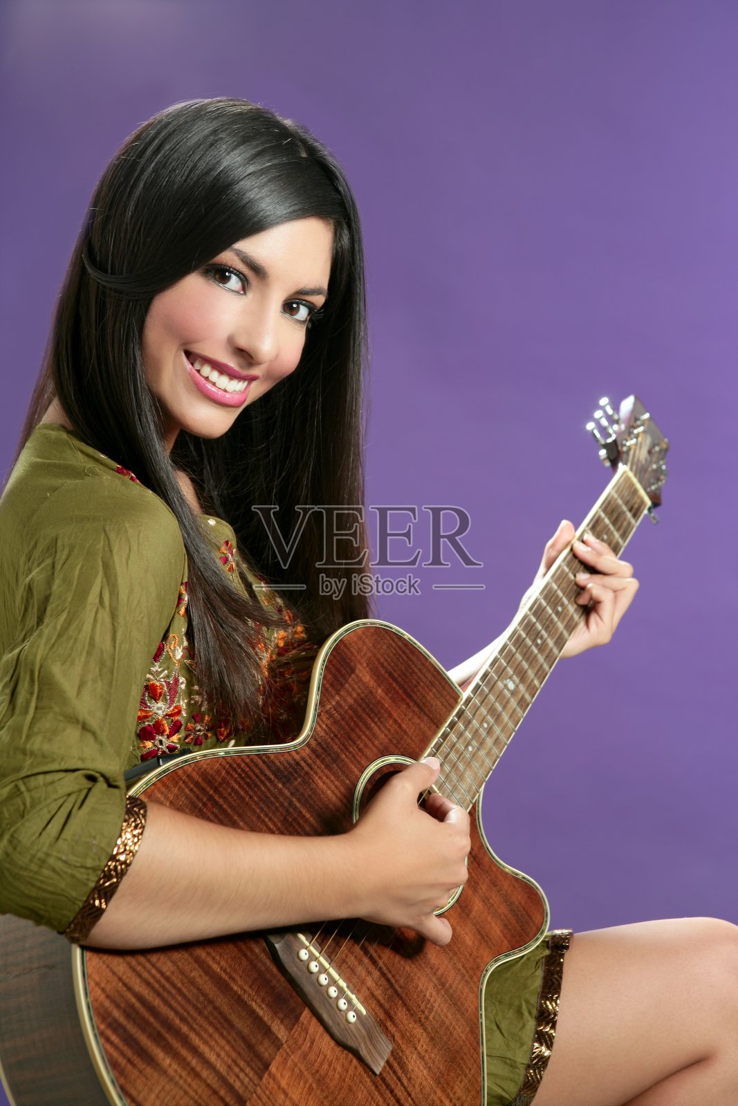 美丽的黑发女郎在弹原声吉他照片摄影图片