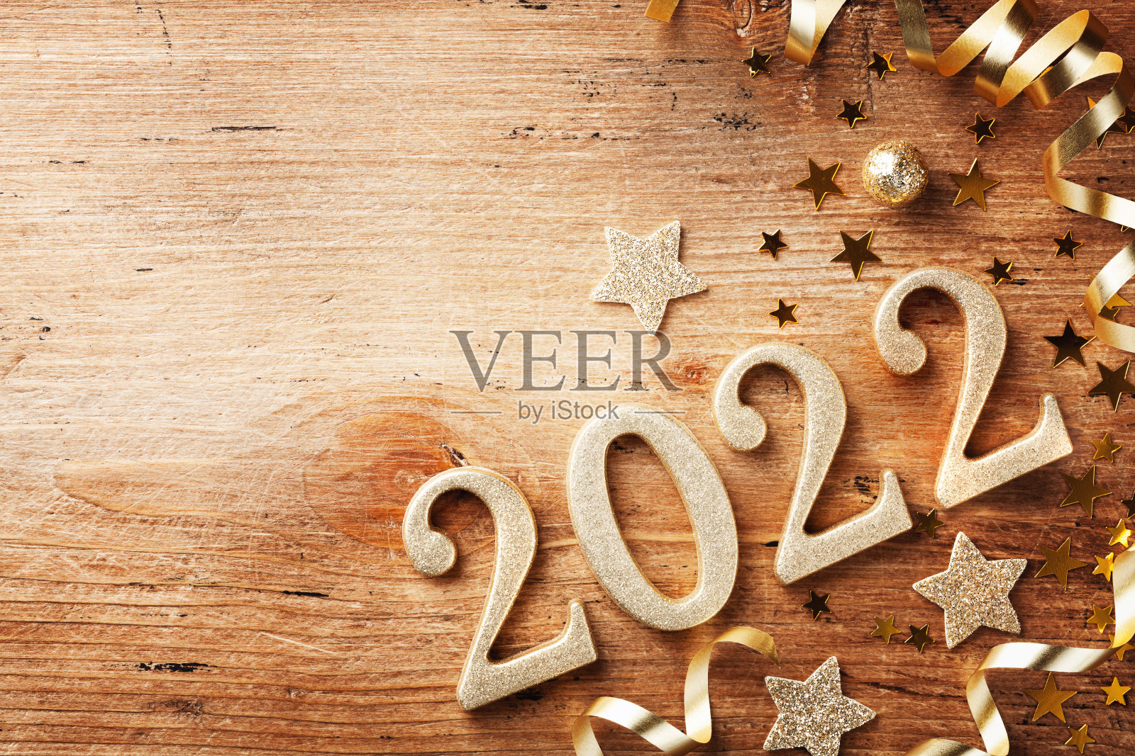 快乐的新年节日背景与黄金数字2022和圣诞节装饰木制桌子顶部视图。照片摄影图片