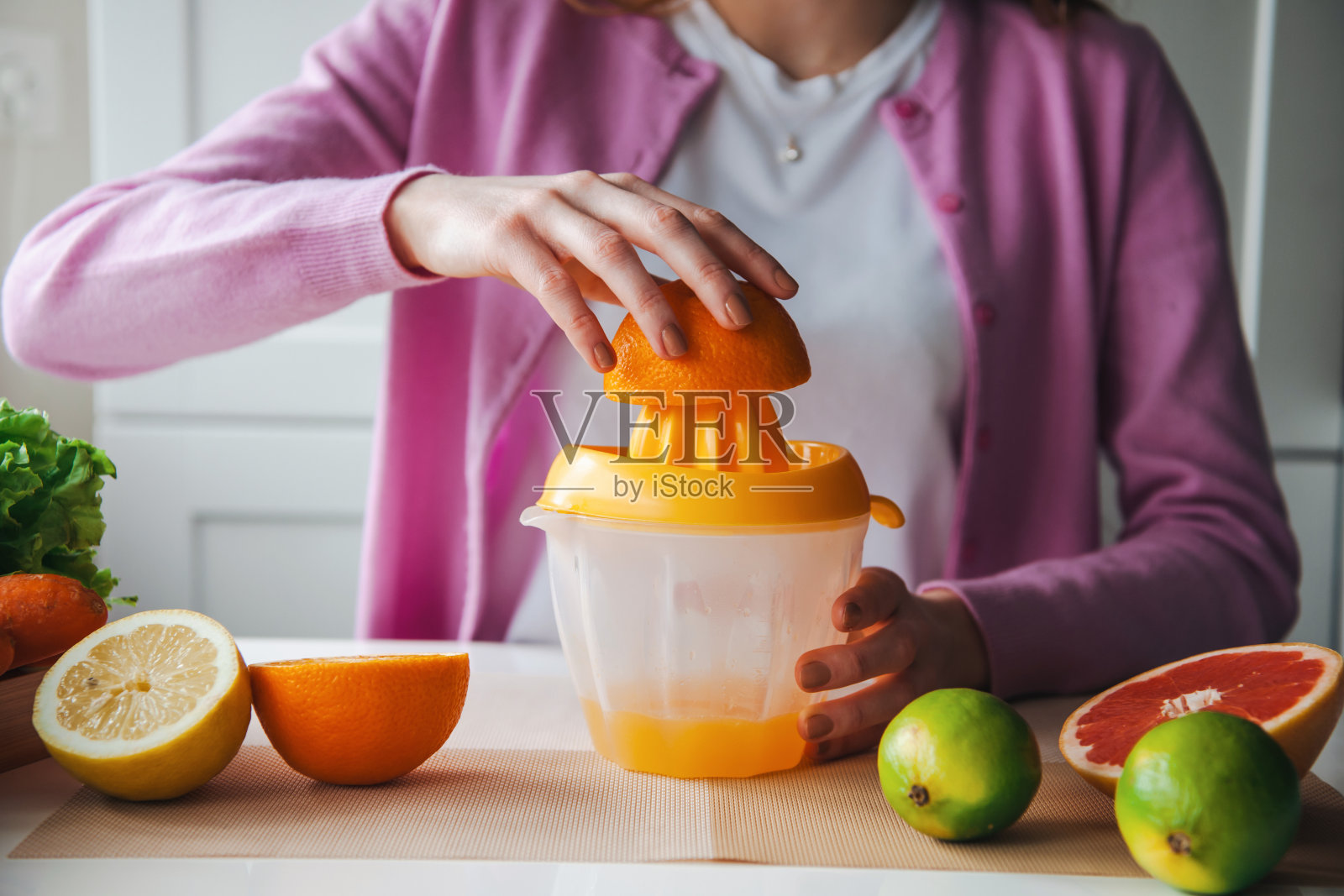 一个女人在家里做新鲜果汁。健康的生活方式。早上例行照片摄影图片