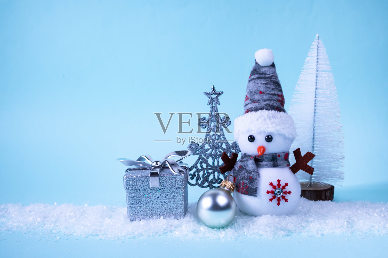 雪人，礼物，圣诞树，圣诞球在白雪皑皑的绿松石背景上。圣诞新年卡片。题字的地方。照片摄影图片