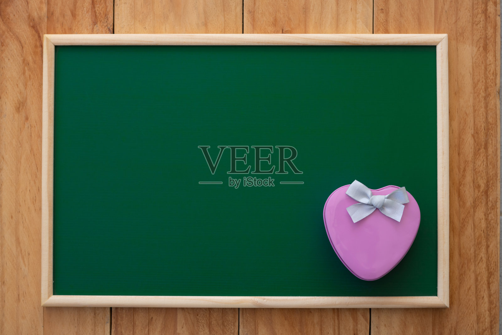 粉色心形的礼品盒在绿色的黑板上。顶视图组成。照片摄影图片