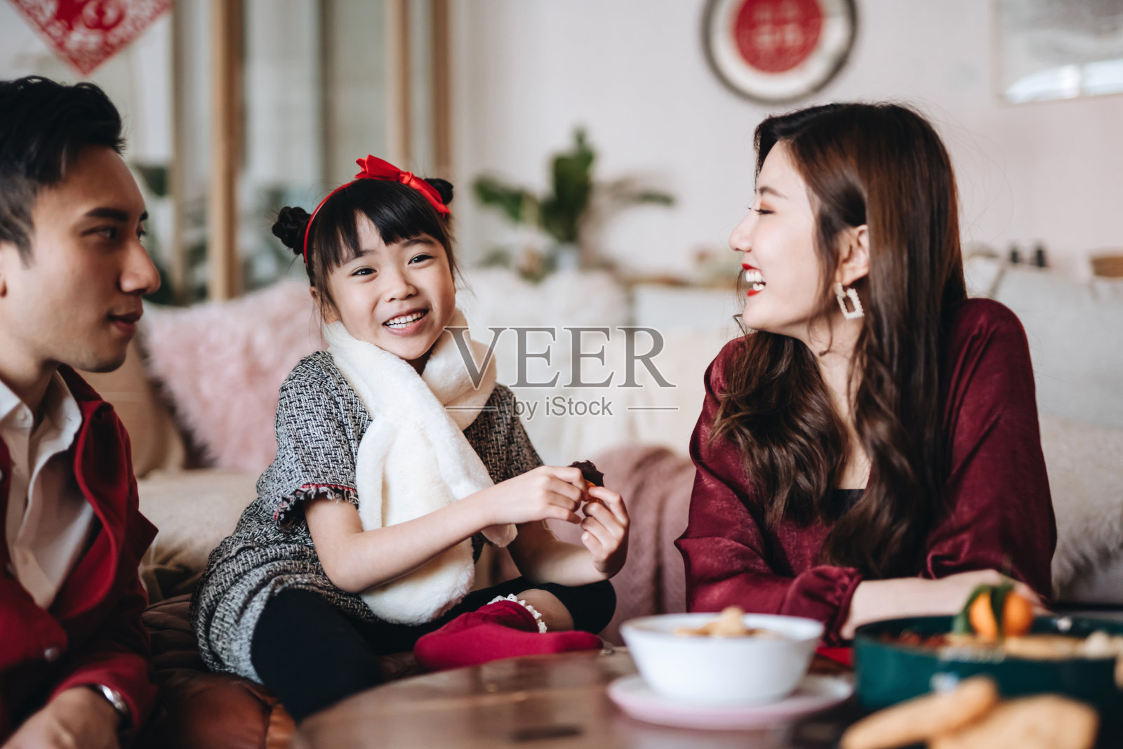 亚洲妈妈和爸爸在温馨的家中与可爱的女儿聊天，享受家庭团聚的时光照片摄影图片