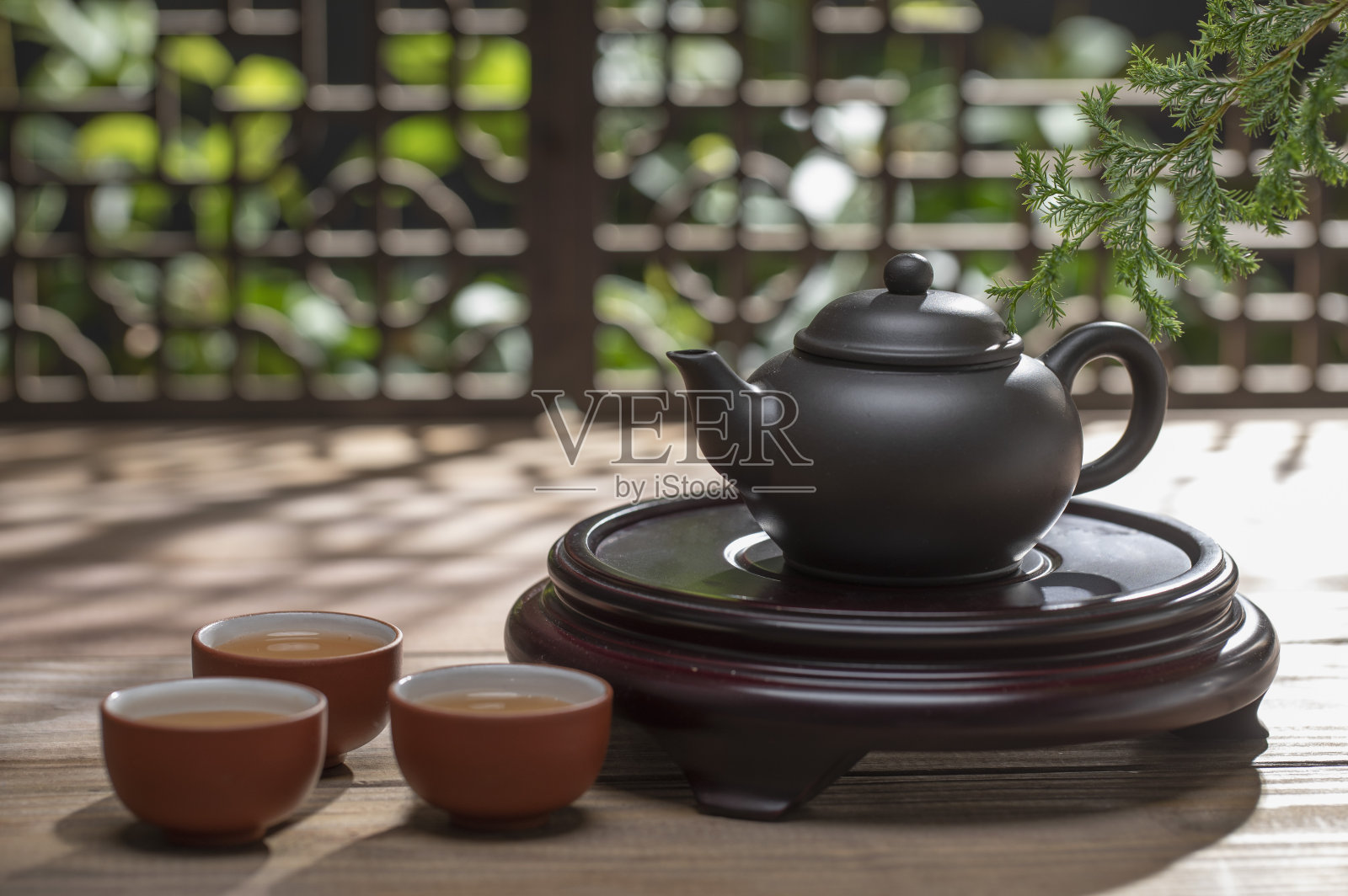 光影下的中国茶壶和茶杯在桌上照片摄影图片