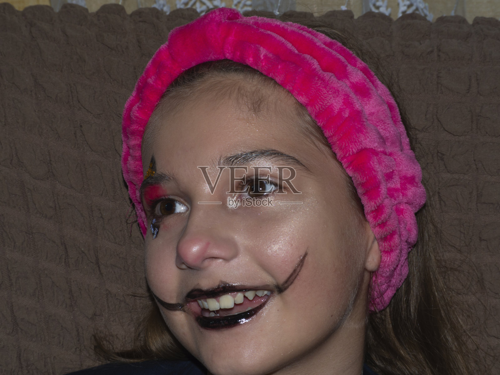 一个可爱的微笑女孩的肖像与节日化妆在她的脸上照片摄影图片