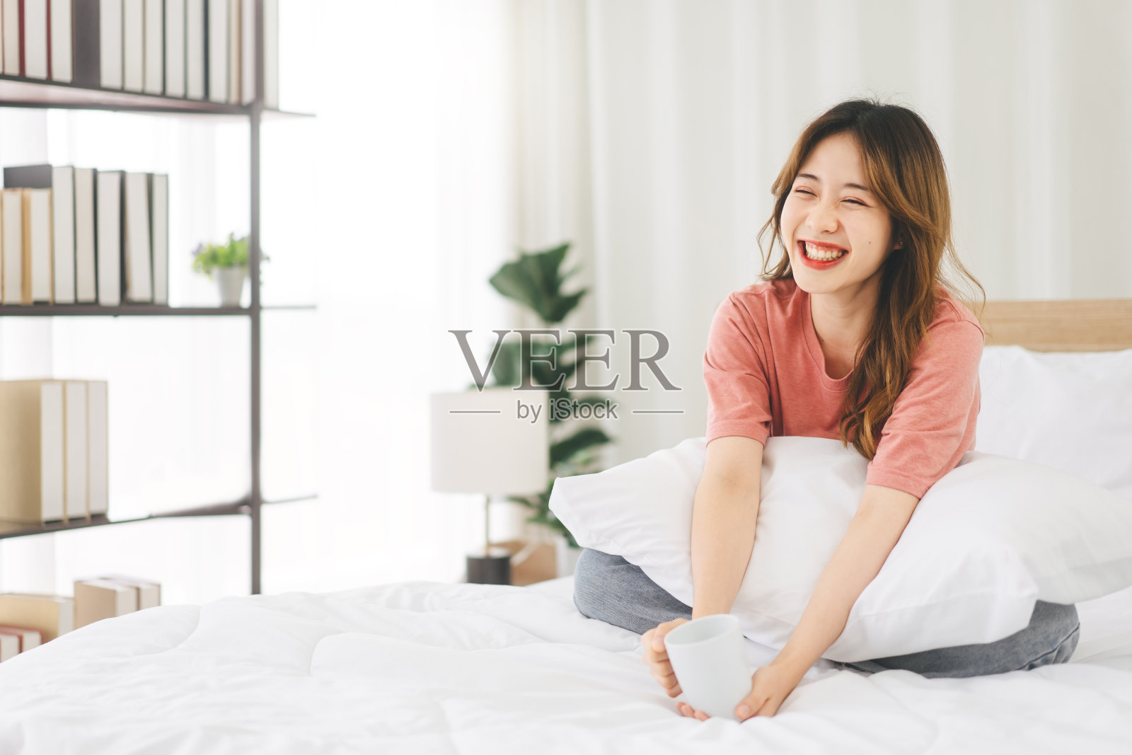 画像年轻的成年亚洲妇女坐在床上快乐的脸后，早晨醒来照片摄影图片