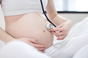 不认识的孕妇正在接受医生的产前检查图片素材